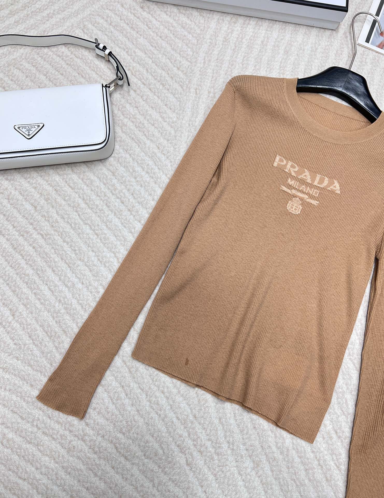 🆕 PRADA 胸口经典logo嵌花短款长袖针织衫，这款修身版型针织长袖源自经典罗纹针织系列 简洁修身版