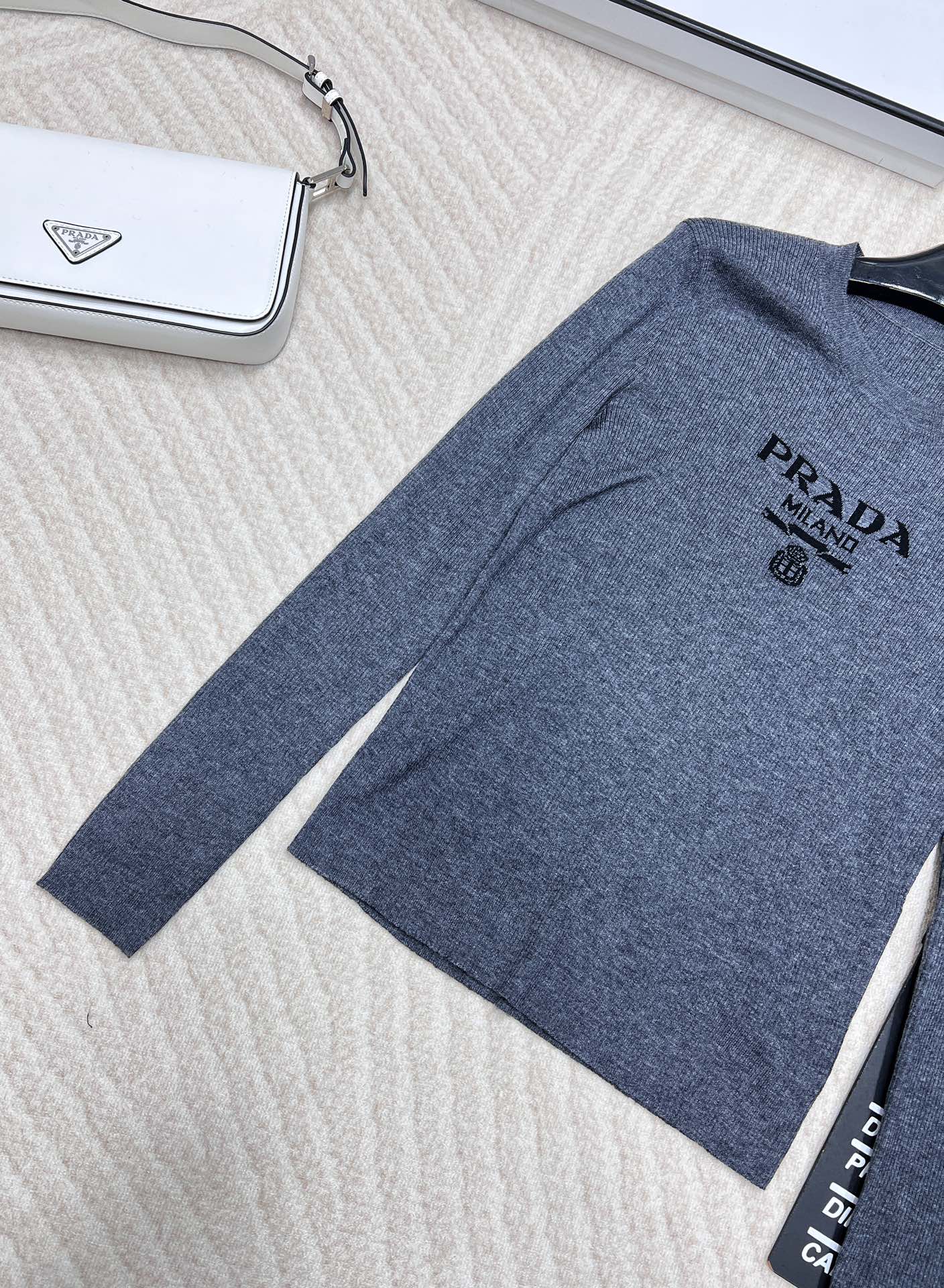 🆕 PRADA 胸口经典logo嵌花短款长袖针织衫，这款修身版型针织长袖源自经典罗纹针织系列 简洁修身版