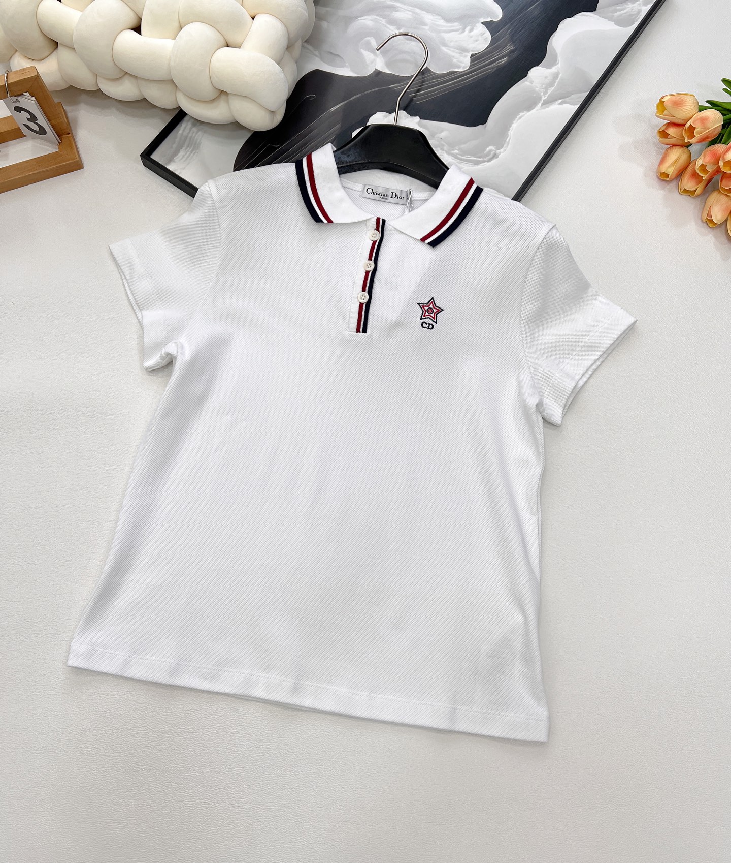 NO:430078,DIOR25SS spring and summer new white tennis style polo shirt short-sleeved top, white cotton-blend jersey fabric three-color logo polo short-sleeved T This Polo short-sleeved T comes from Vibe limited series Reinterpreting the classic logo of sports style and highlighting the spirit of high ordering. Elaborately crafted with white cotton-blend jersey fabrics Regular style Side slit design Collar and button placket with three-color striped trim The front is decorated with classic logo and star embroidery, making it more refined. Combining elegant temperament with the aesthetic style of sports clothing. It can be worn with other items in Vibe limited series Create a delicate look The chest is decorated with letter logo and classic star embroidery Polo collar with button placket Mother of pearl buttons, three marks are complete, one series size sml code, dior, T-shirt, alexander wang19860909DIOR25SS春夏新款白色网球风polo衫短袖上衣,白色棉质混纺平纹针织面料三色标志polo短袖T 这款Polo短袖T来自Vibe限定系列 重新诠释运动风格经典标识 彰显高订精神 采用白色棉质混纺平纹针织面料精心制作 常规版型 侧边开叉设计 衣领和纽扣门襟搭配三色条纹饰边 正面饰以经典标志和星星刺绣,更显精致 将高雅气质与运动服饰的美学风格相结合 可与Vibe限定系列的其他单品搭配穿着 打造精致的造型 胸前饰以字母标志和经典星星刺绣 Polo领搭配纽扣门襟 珍珠母贝纽扣,三标齐全,一个系列出 尺码sml 编码,,dior,T-shirt,alexander wang,Women's clothing