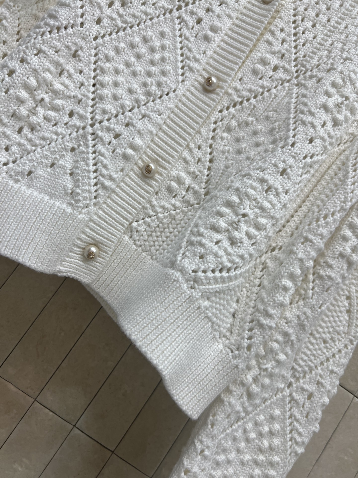 D家 26春夏新款 白色镂空针织开衫 轻薄透气 几何镂空+珍珠纽扣 细节超精致 短款剪裁 搭高腰裤/裙都