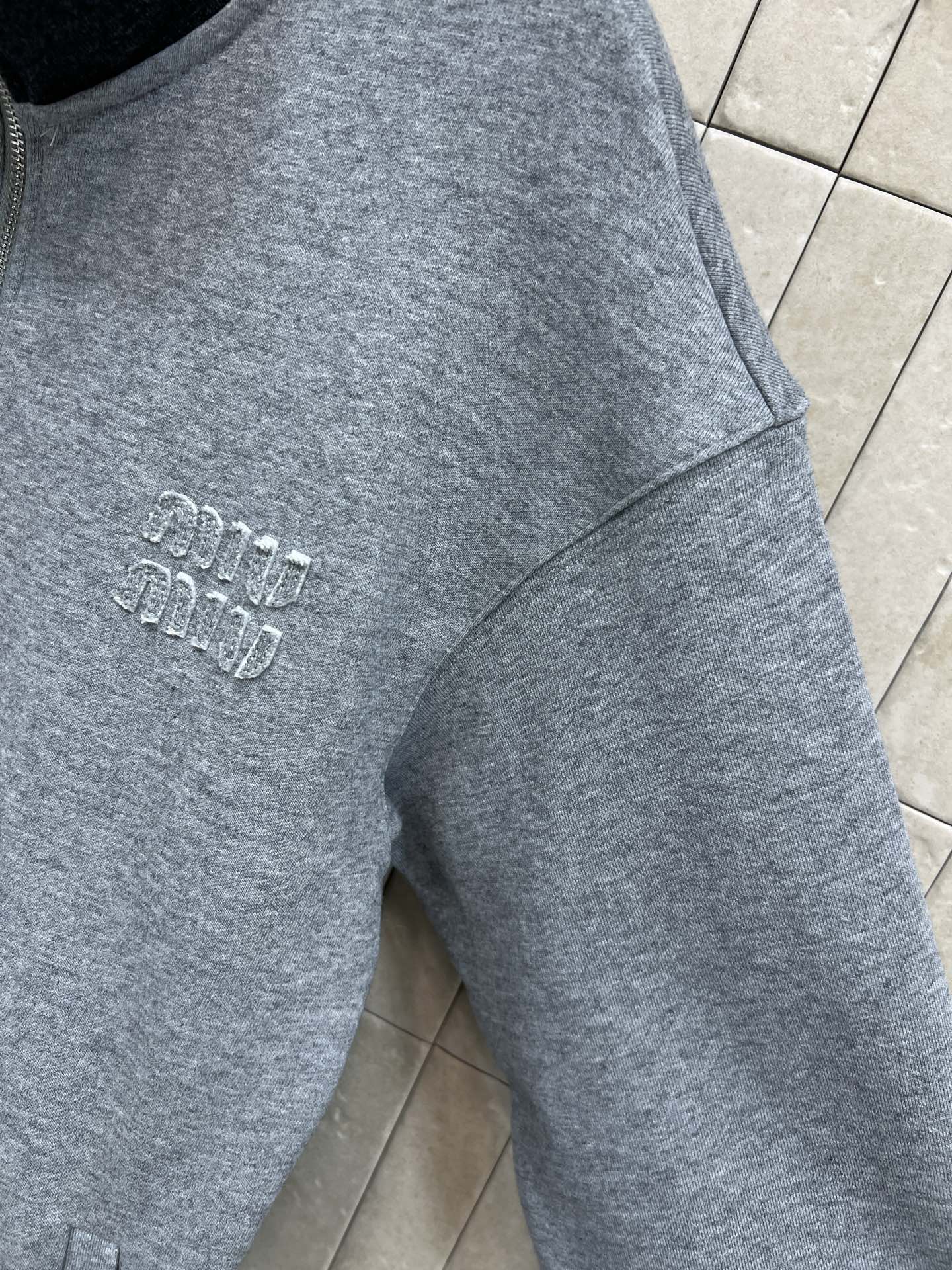 MIU家 25秋冬新款 灰色立领拉链卫衣外套 经典飞行员夹克版型 羊毛混纺材质柔软舒适 黑色高领设计 胸