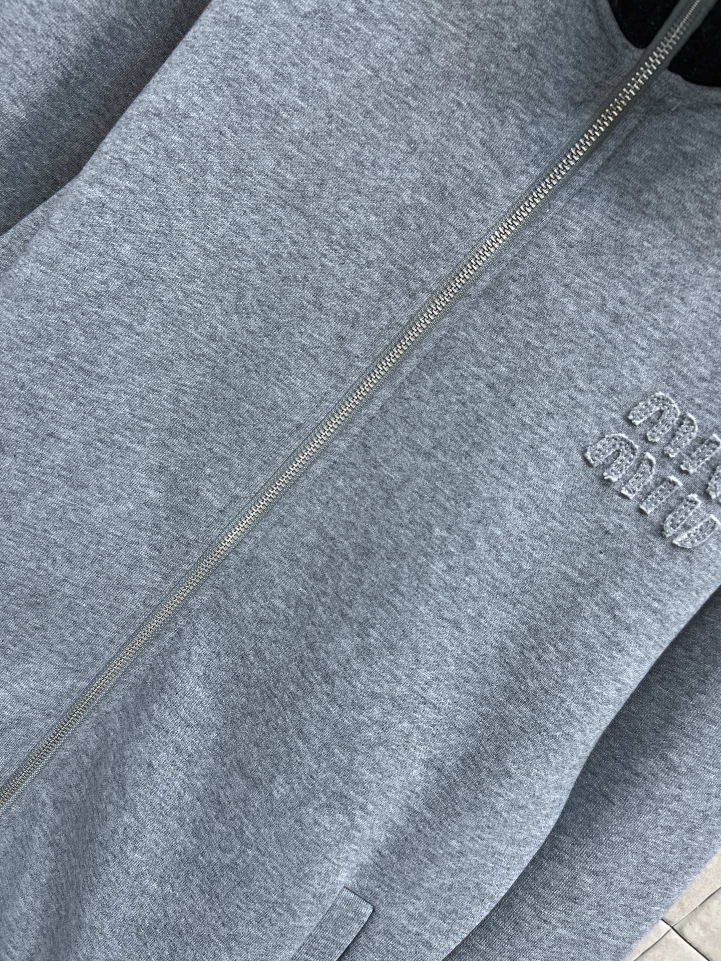 MIU家 25秋冬新款 灰色立领拉链卫衣外套 经典飞行员夹克版型 羊毛混纺材质柔软舒适 黑色高领设计 胸