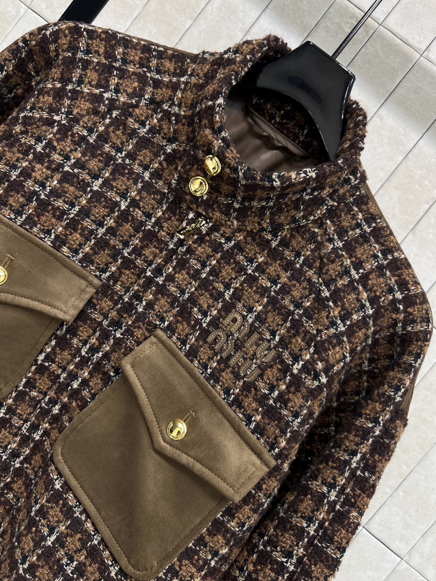 26春夏新款 粗花呢外套 经典棕色格纹设计 混纺粗花呢材质 质感厚实又保暖 立领+金属纽扣+翻盖口袋 细