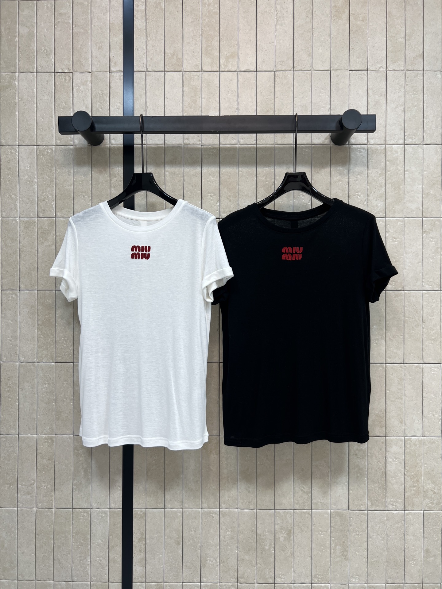 NO:803830,MIU's 26 spring and summer new style round neck short-sleeved T-shirt. Light and slightly transparent. Smooth and soft. Straight-shoulder and loose fit. The logo on the chest is exquisite but not monotonous. The logo on the chest is exquisite and not monotonous. It is versatile and not picky. It can be easily managed in daily casual or street style. Comfortable and stylish. Pair it with jeans or cargo shorts to easily get a sense of trend.  Two colors and three codes Size/S-M-L,,miumiu,shorts,jeans,T-shirt,tees,t-shirt,19860909MIU家 26春夏新款 圆领短袖T恤 轻薄微透 垂顺软糯 正肩宽松版型 藏肉显瘦不挑身材 胸前logo精致点睛不单调 百搭不挑人 日常休闲或街头风都能轻松驾驭 舒适又有型 随手搭牛仔裤或工装短裤 轻松get潮流感 两色三码Size/S-M-L,,miumiu,shorts,jeans,T-shirt,tees，t-shirt,,Women's clothing