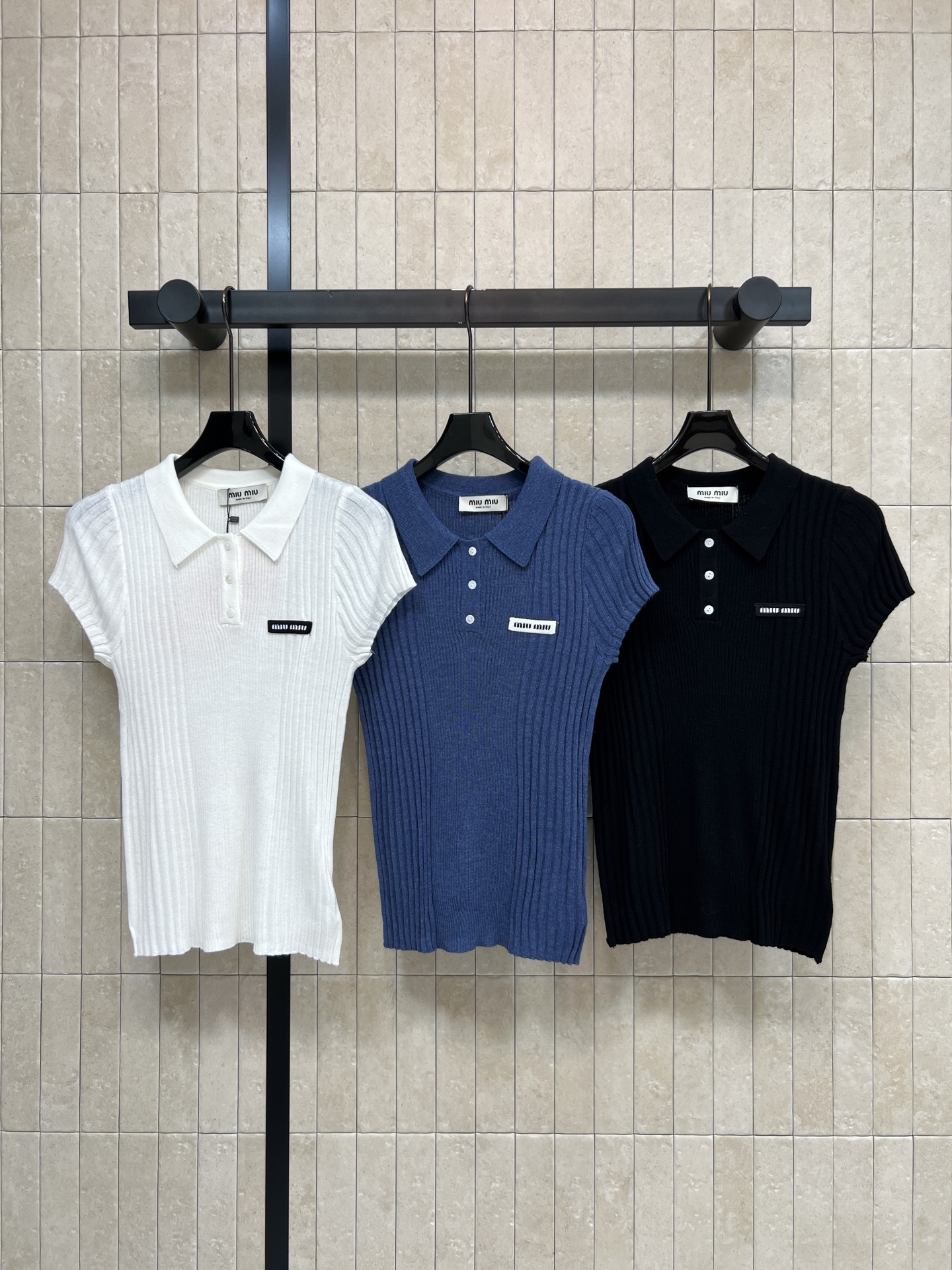 NO:909403,MIU Home 26 new summer style Polo collar knitted short sleeves. Made of wool knitted fabric. Vertical pit strip texture is full of elasticity. Slim and slim. Lapel with half-open button design. Exquisite and eye-catching logo patch on the chest. Neat little flying sleeves modify the arm lines. Fitted version outlines a beautiful figure. Suitable for pairing with denim skirts and casual pants. It shows gentle temperament for daily commuting and dating.  Three colors and three codes Size/S-M-L,,miumiu,skirts,T-shirt,19860909MIU家 26夏季新款 Polo领针织短袖 采用羊毛针织面料 竖坑条肌理弹力十足 修身显瘦 翻领搭配半开扣设计 胸前logo贴标精致醒目 利落小飞袖修饰手臂线条 合身版型勾勒优美身形 搭配牛仔短裙 休闲裤都很合适 日常通勤 约会都尽显温柔气质 三色三码Size/S-M-L,,miumiu,skirts,T-shirt,,Women's clothing