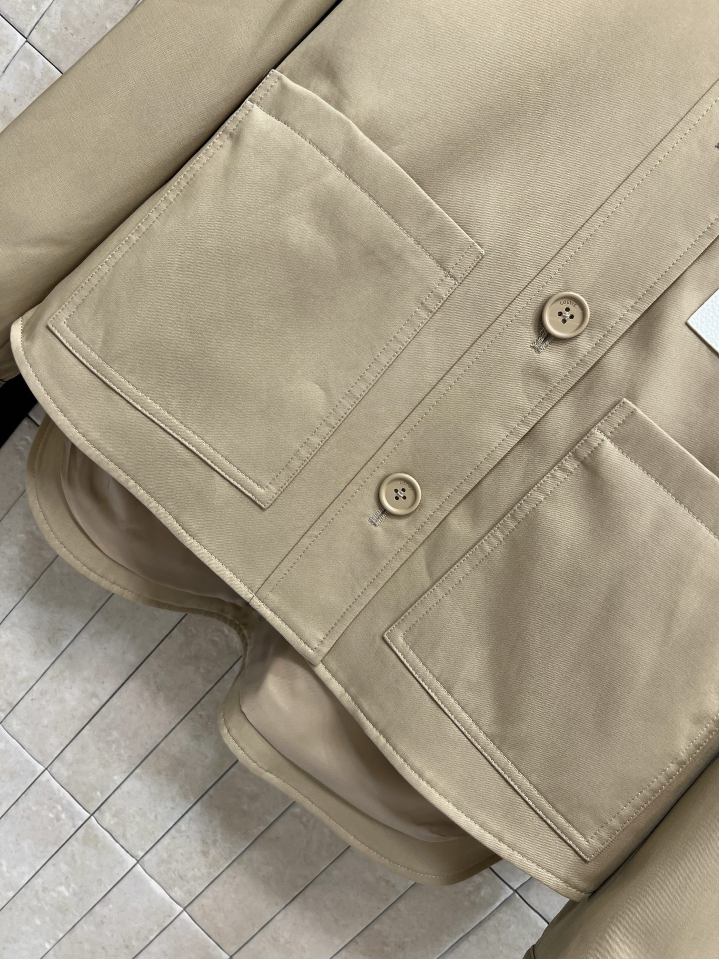 LW家 26早秋新款 卡其色夹克外套 采用棉质混纺面料 翻领单排同色系纽扣开合 胸前白色皮革点缀品牌标识 设计感突出 下