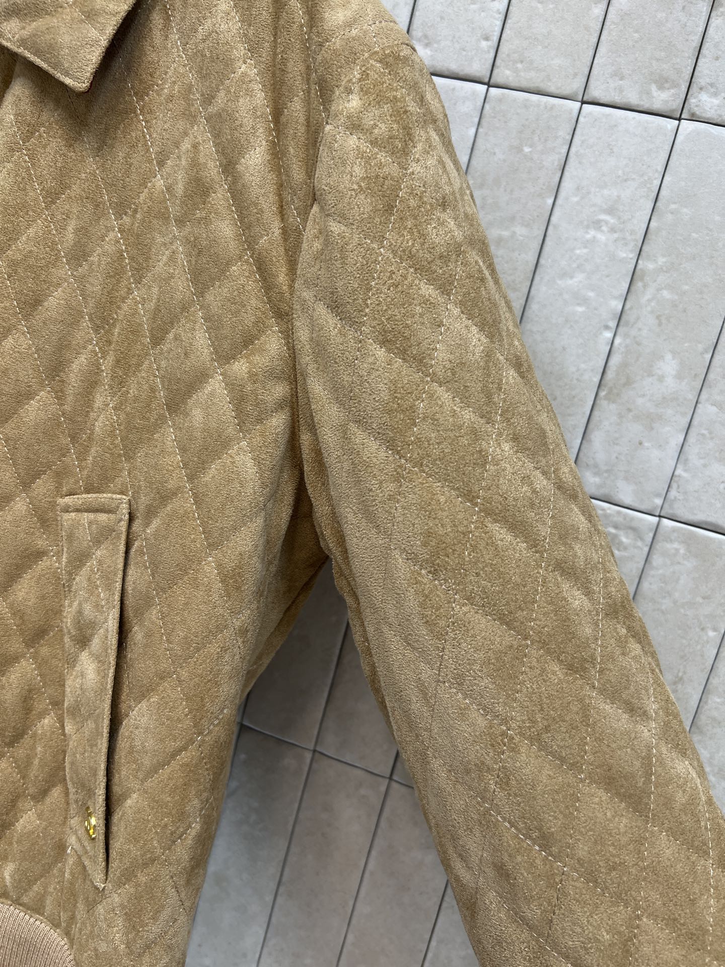 C家 26早秋新款 卡其色短款外套 利落翻领搭配金色拉链 衣身整片菱格衍缝 肌理饱满有型 侧边贴袋点缀精致logo 下摆
