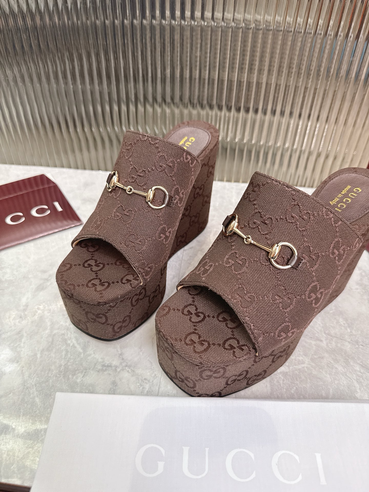 Gucci 标志性的马衔扣和 的双G提花图案在最新的古驰系列中以当代方式重新诠释 这款楔形凉拖鞋采用GG帆布制作