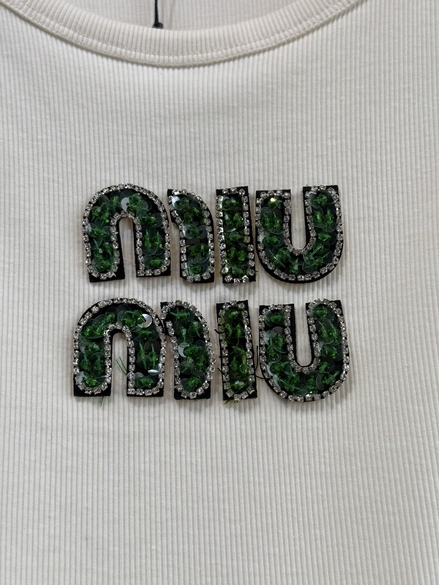 Miu Miu刺绣徽标针织背心
这款线条简约的针织上衣增添了亮丽的色彩与标志性元素。风格百搭，适合搭配各