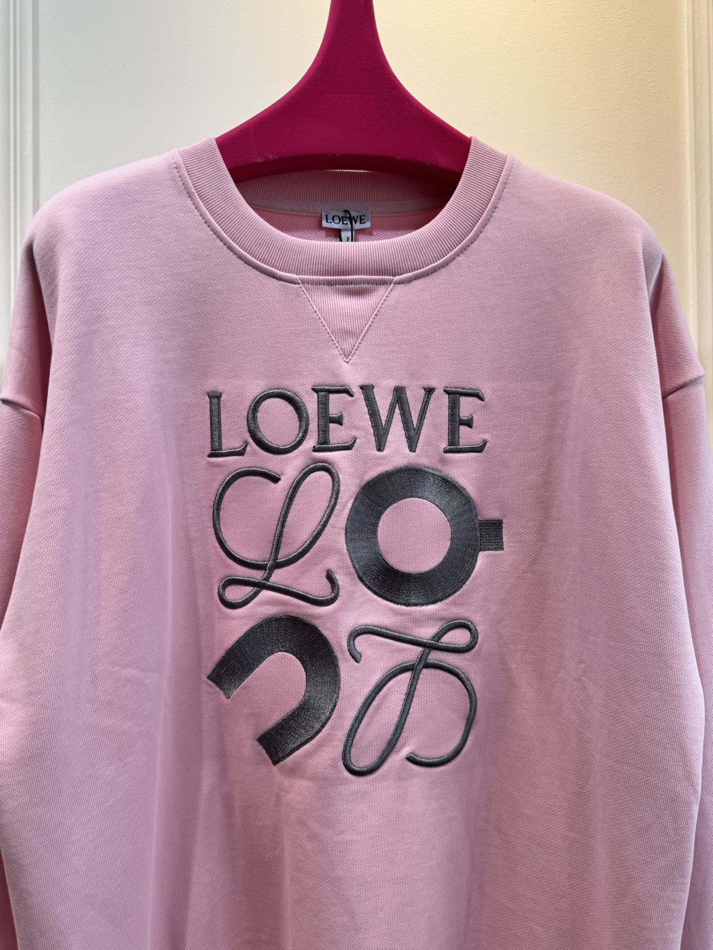 LOEW*圆领卫衣，•颜色：选用柔和的粉色，甜美且充满少女感，在视觉上给人温馨、柔和的感觉，比较适合春秋