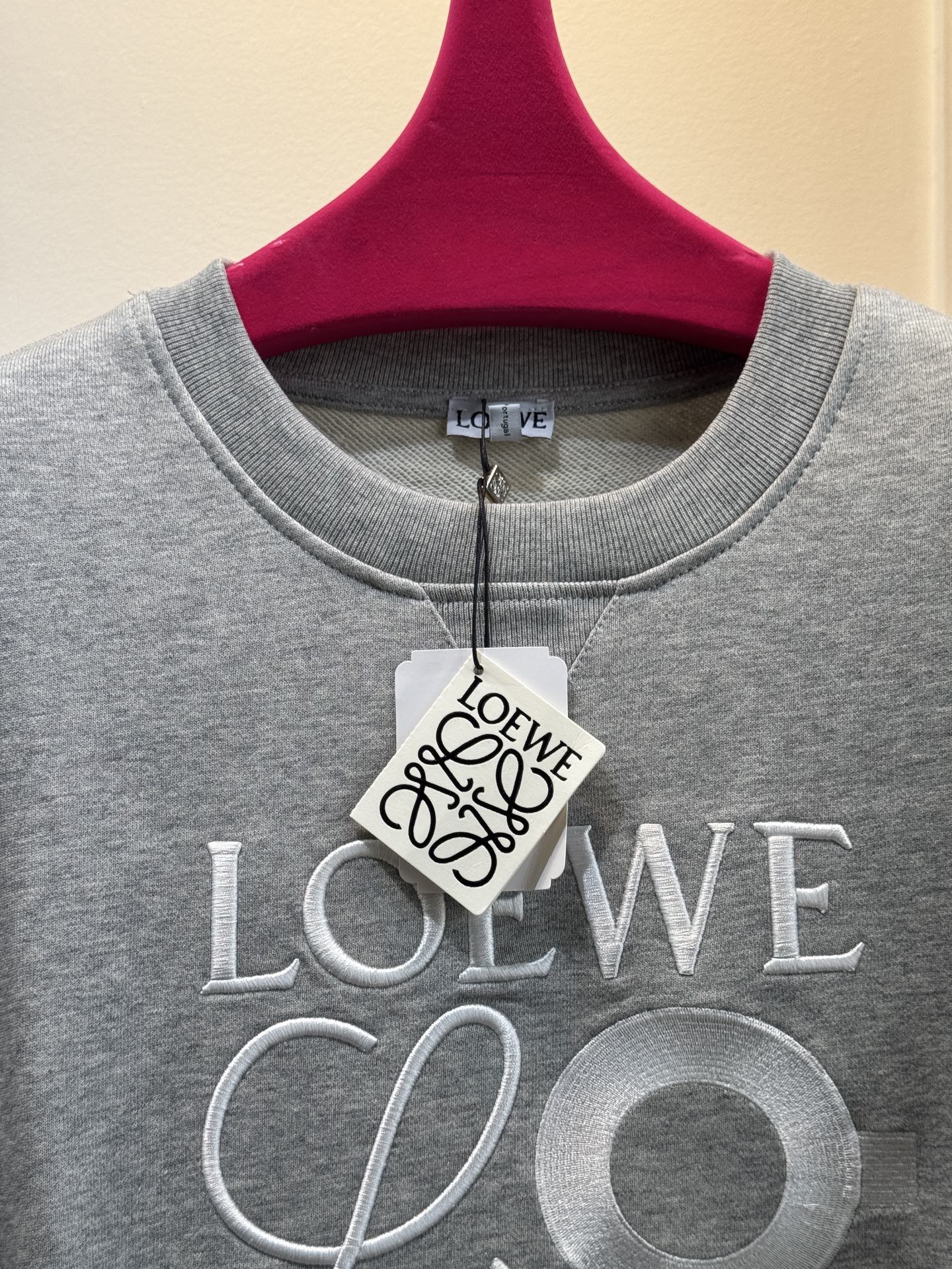 LOEW*圆领卫衣，•颜色：选用柔和的粉色，甜美且充满少女感，在视觉上给人温馨、柔和的感觉，比较适合春秋