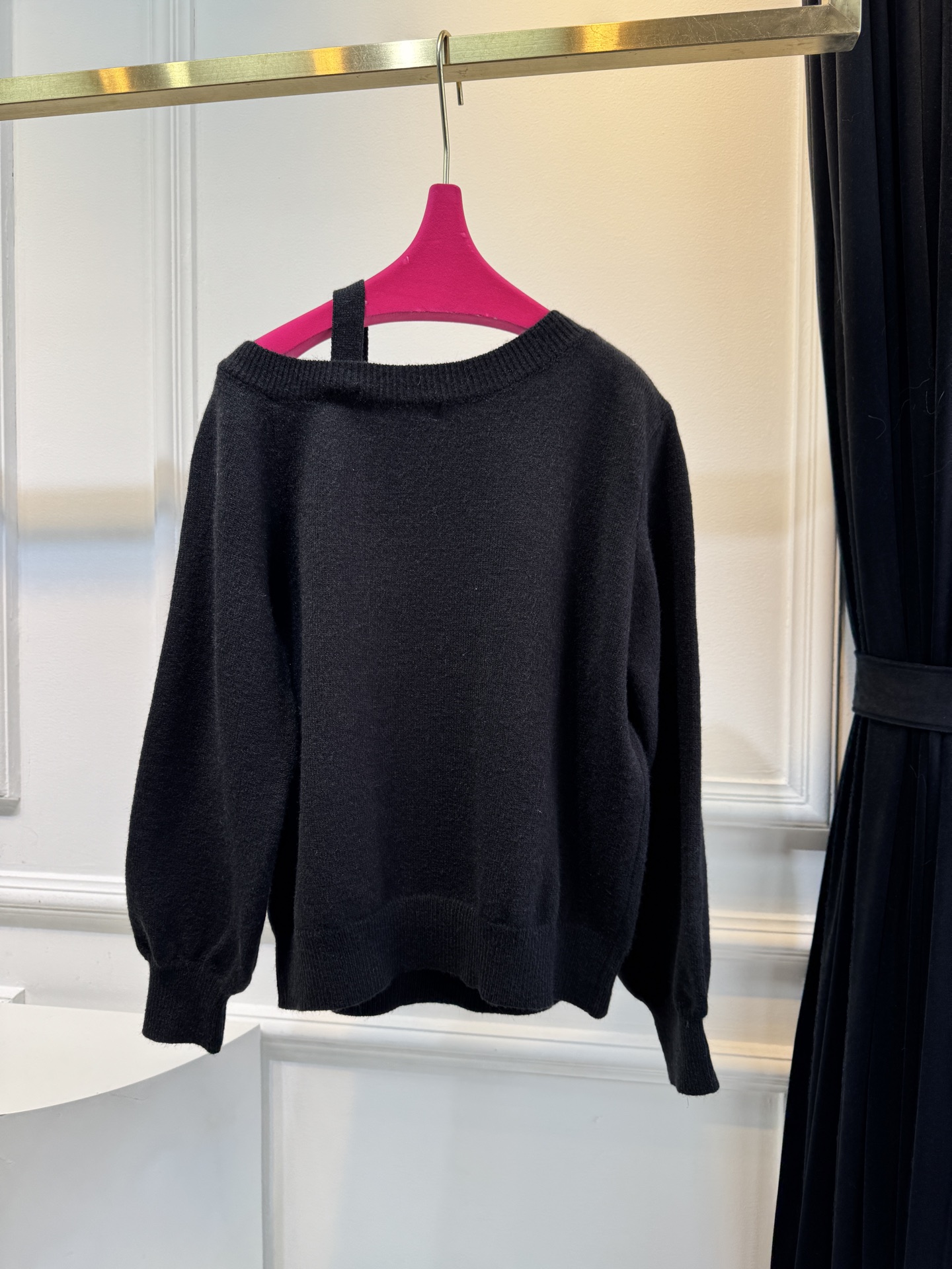 schiaparelli 侧纽扣设计的米白色针织衫短款版型，侧边采用斜排金属纽扣设计，兼具装饰性与实用性