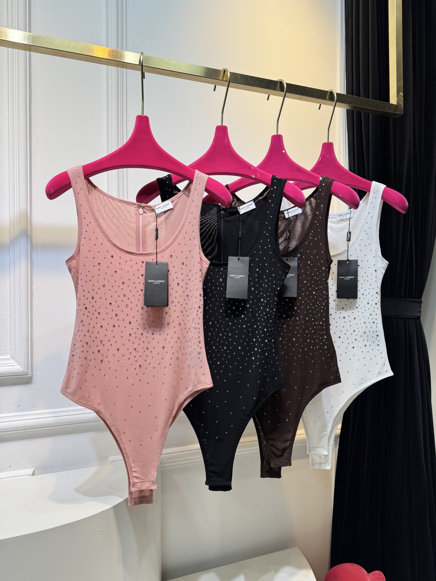 slp水钻连体衣通体装饰水钻，采用无袖、低圆领剪裁，背部配备拉链与底部按扣设计，兼具装饰性与穿脱便利性融