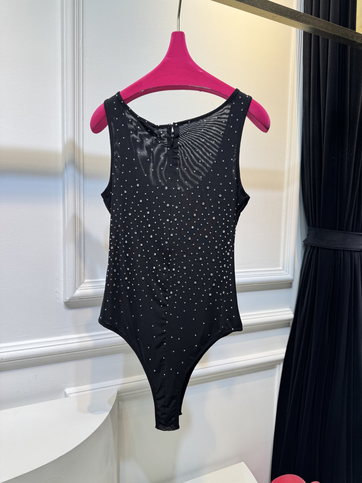 slp水钻连体衣通体装饰水钻，采用无袖、低圆领剪裁，背部配备拉链与底部按扣设计，兼具装饰性与穿脱便利性融