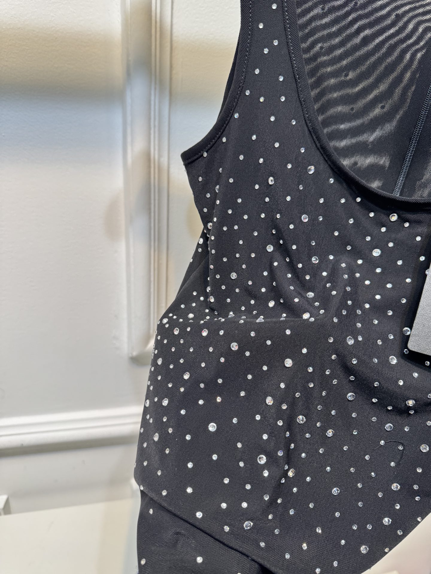 slp水钻连体衣通体装饰水钻，采用无袖、低圆领剪裁，背部配备拉链与底部按扣设计，兼具装饰性与穿脱便利性融