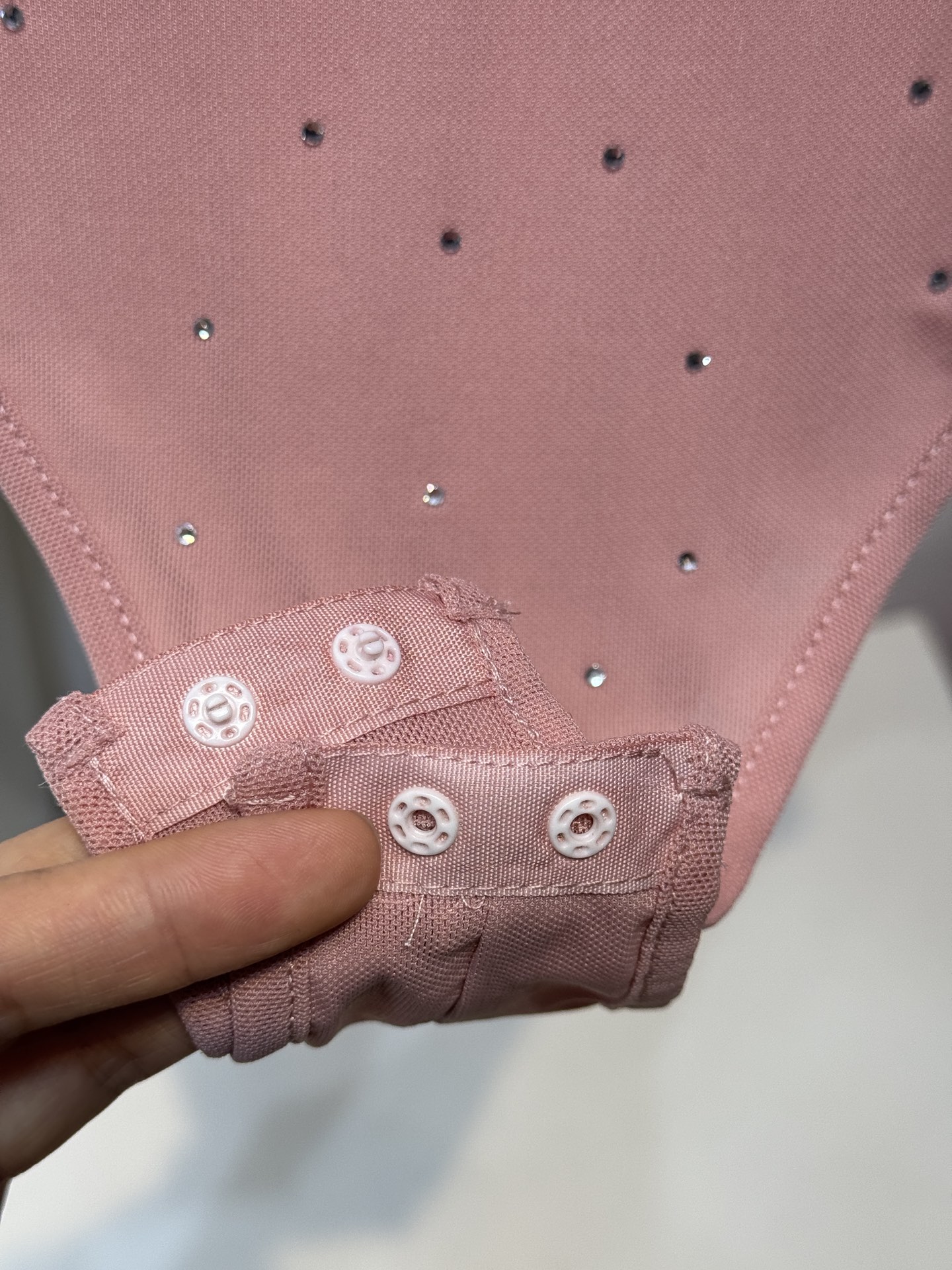 slp水钻连体衣通体装饰水钻，采用无袖、低圆领剪裁，背部配备拉链与底部按扣设计，兼具装饰性与穿脱便利性融