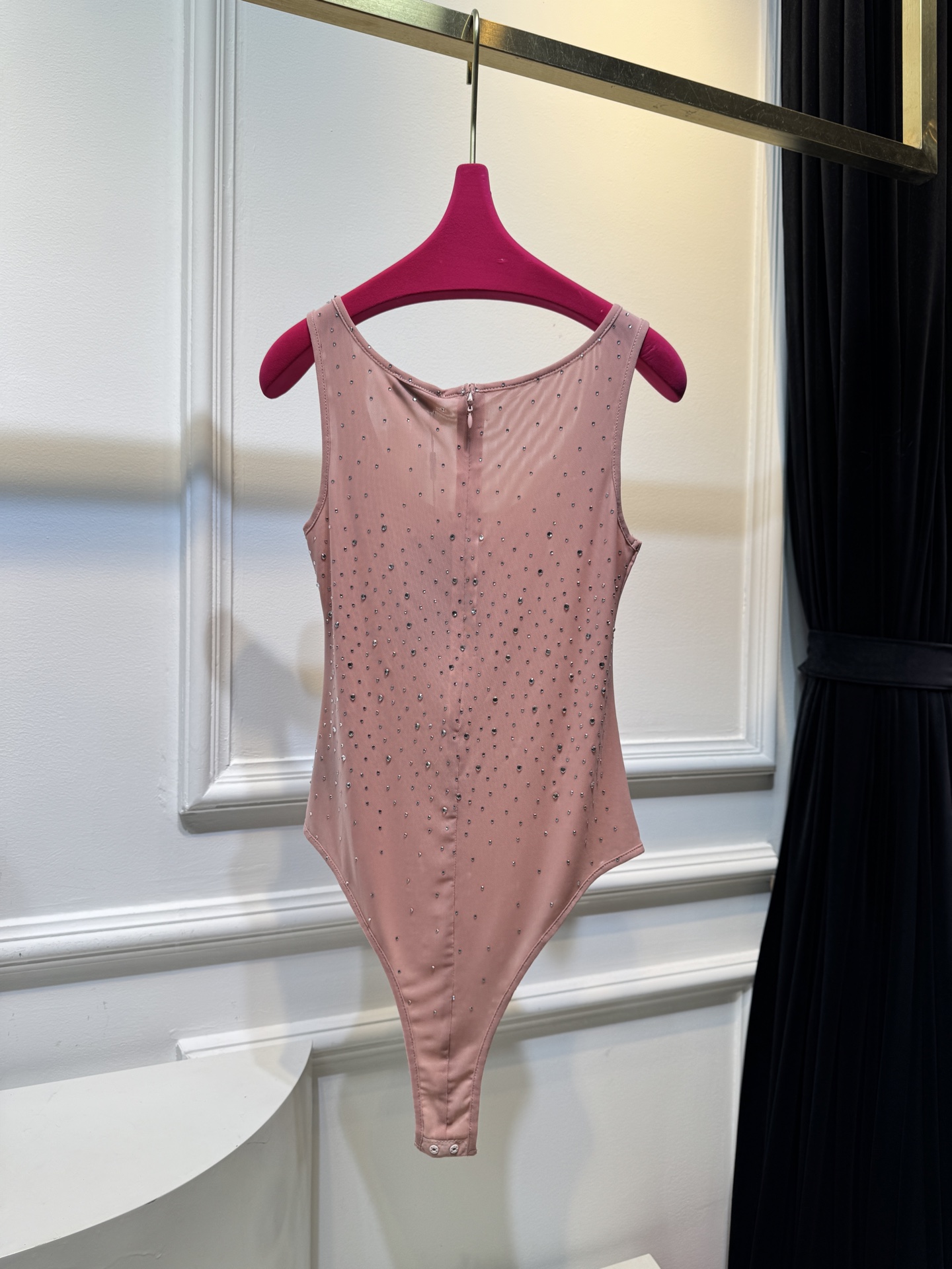 slp水钻连体衣通体装饰水钻，采用无袖、低圆领剪裁，背部配备拉链与底部按扣设计，兼具装饰性与穿脱便利性融