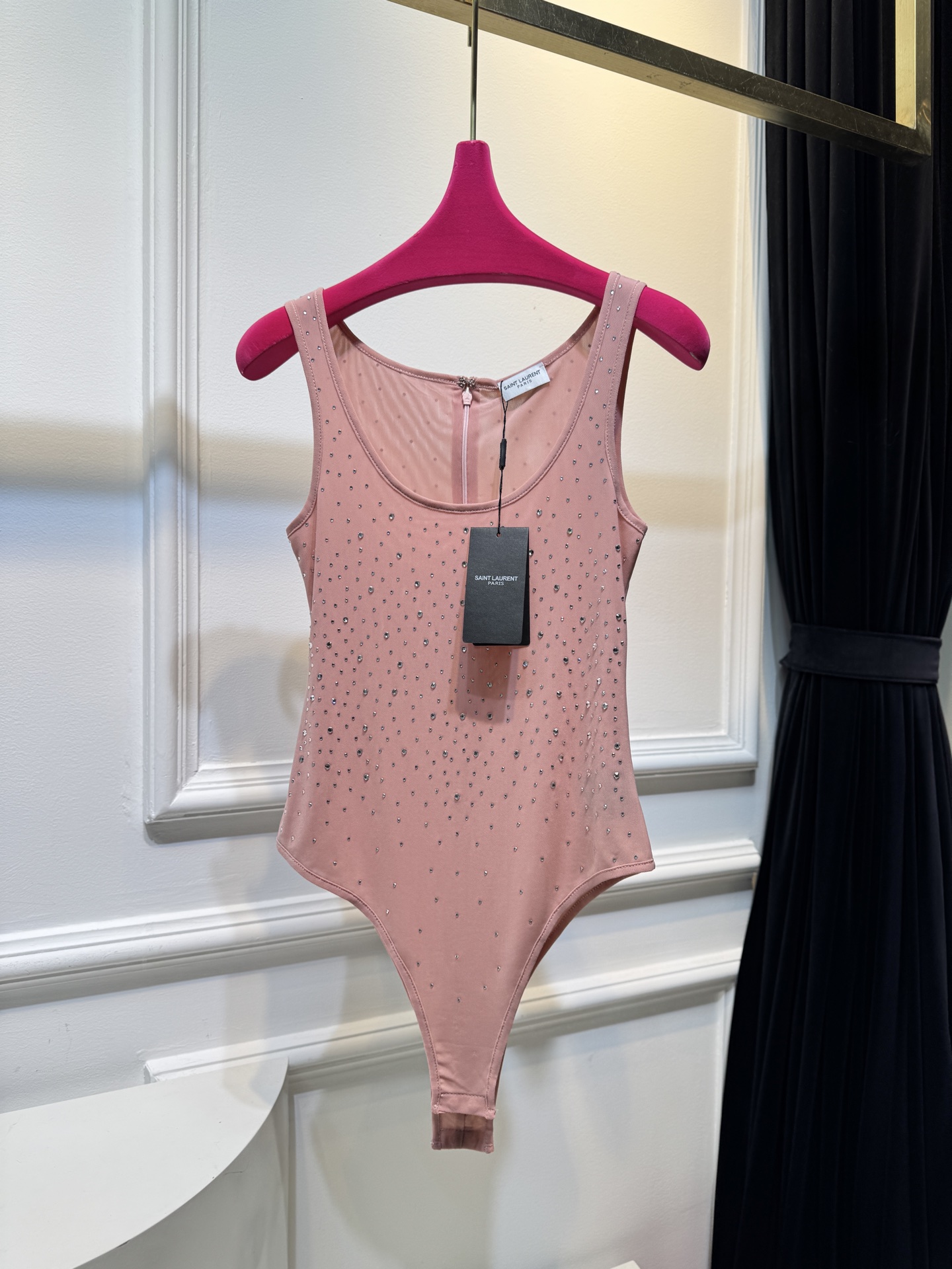 slp水钻连体衣通体装饰水钻，采用无袖、低圆领剪裁，背部配备拉链与底部按扣设计，兼具装饰性与穿脱便利性融