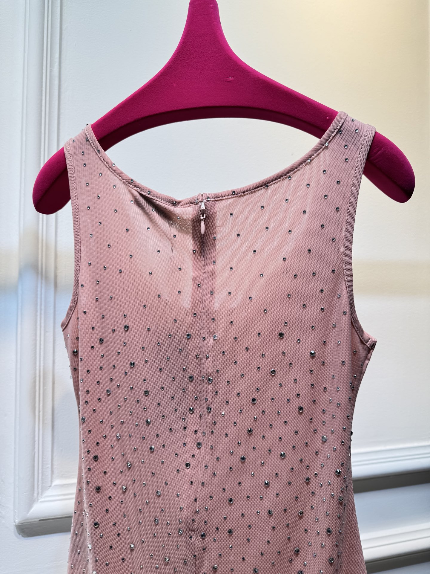 slp水钻连体衣通体装饰水钻，采用无袖、低圆领剪裁，背部配备拉链与底部按扣设计，兼具装饰性与穿脱便利性融