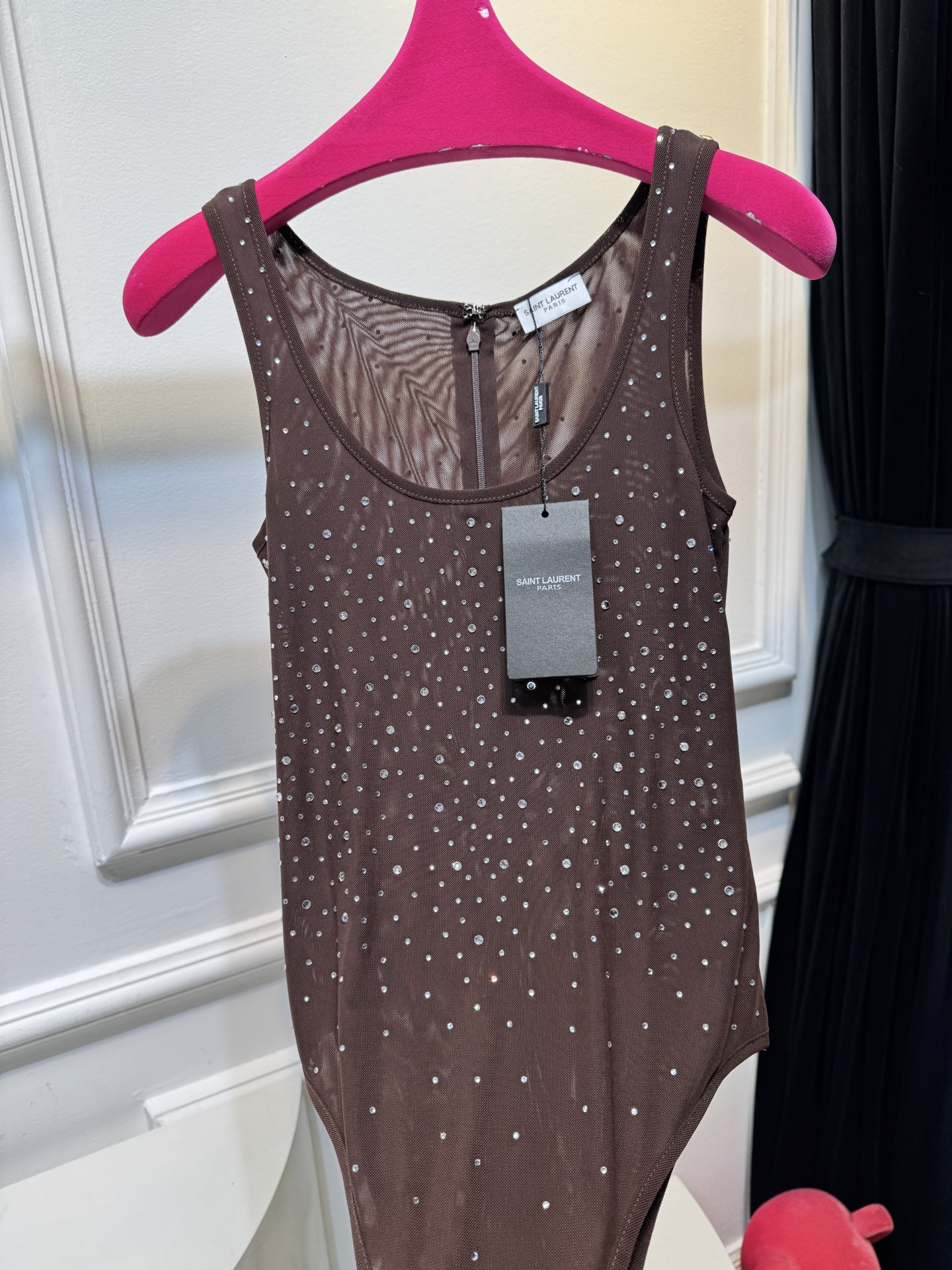 slp水钻连体衣通体装饰水钻，采用无袖、低圆领剪裁，背部配备拉链与底部按扣设计，兼具装饰性与穿脱便利性融