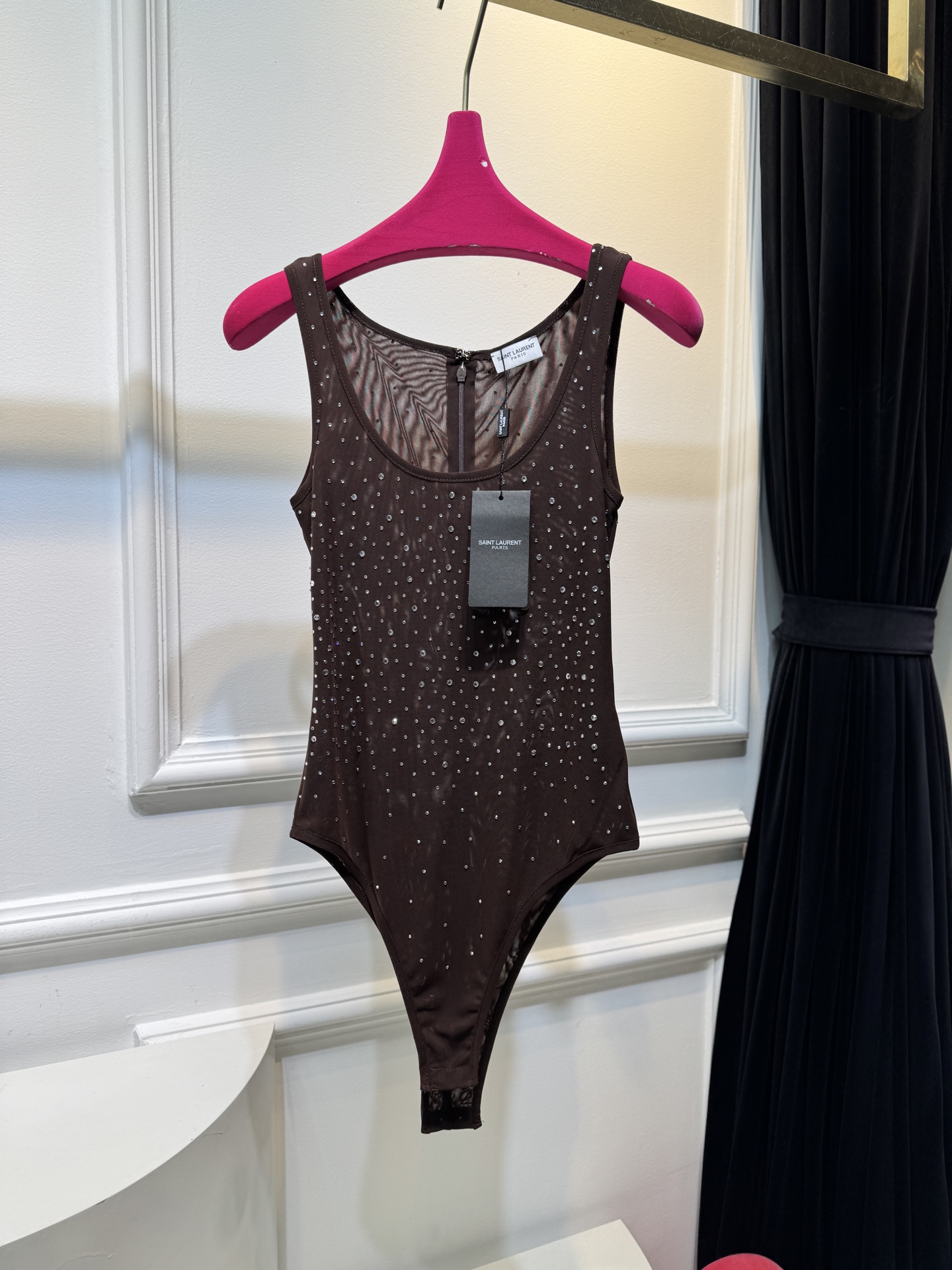 slp水钻连体衣通体装饰水钻，采用无袖、低圆领剪裁，背部配备拉链与底部按扣设计，兼具装饰性与穿脱便利性融