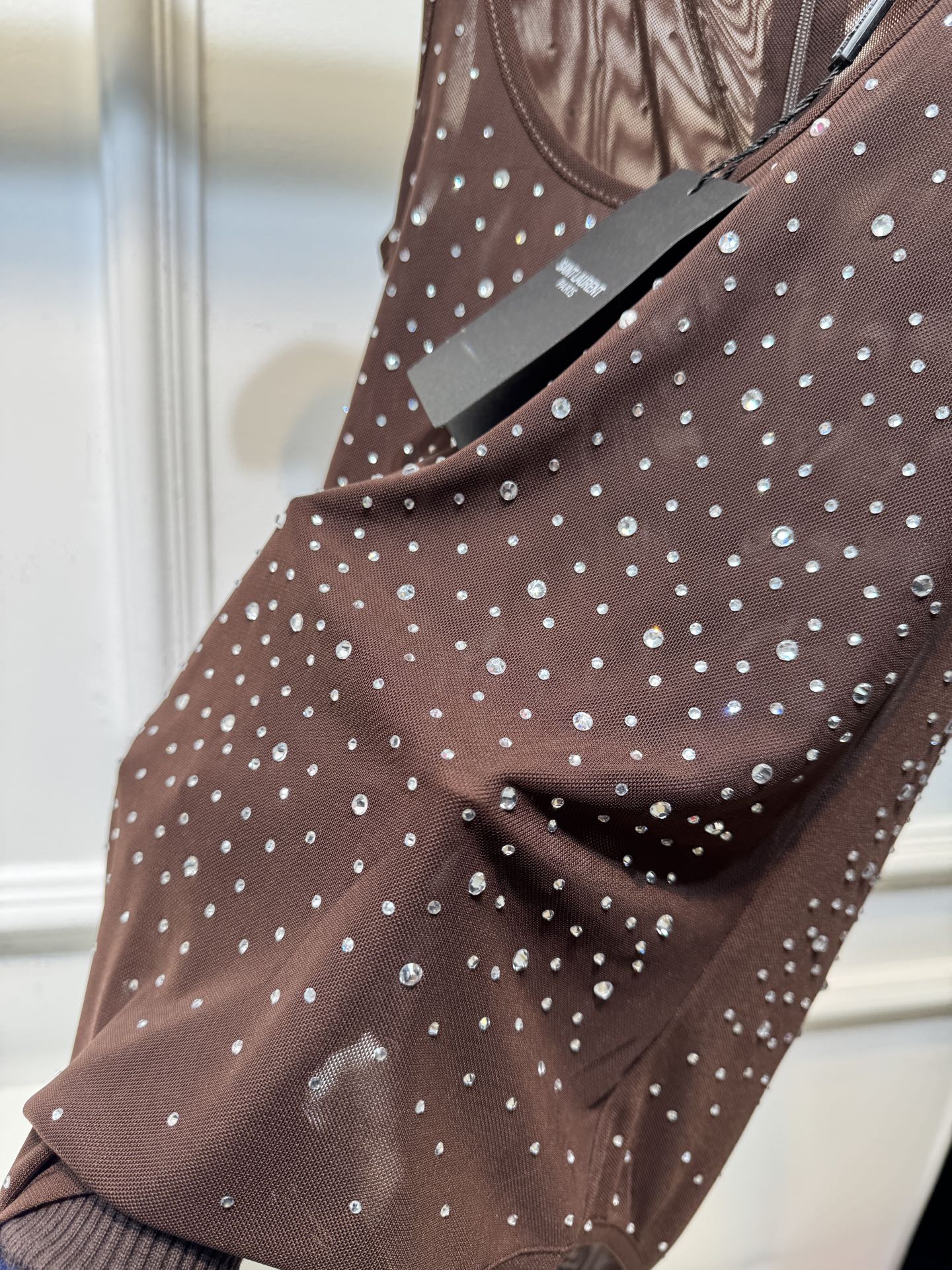 slp水钻连体衣通体装饰水钻，采用无袖、低圆领剪裁，背部配备拉链与底部按扣设计，兼具装饰性与穿脱便利性融