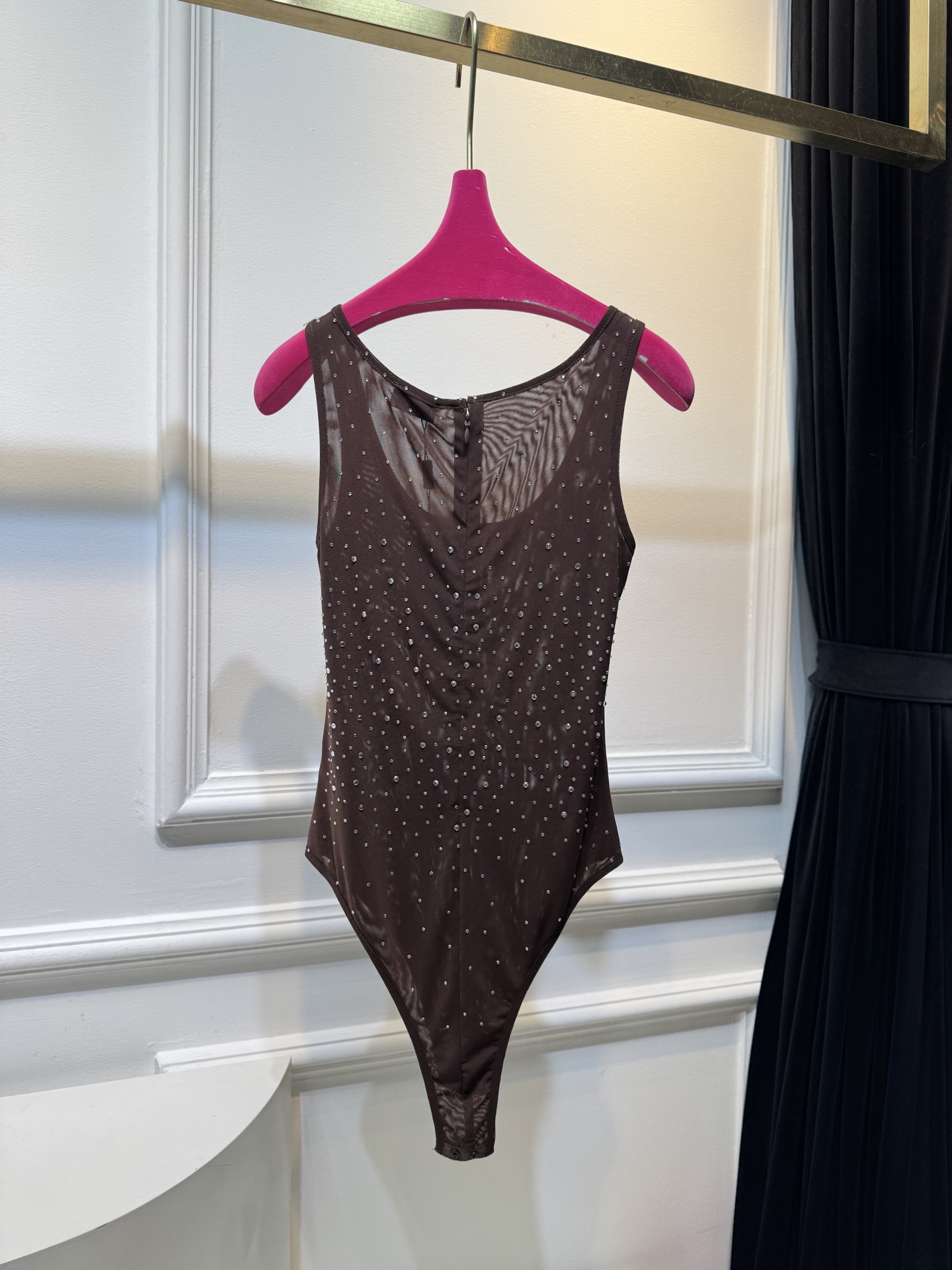 slp水钻连体衣通体装饰水钻，采用无袖、低圆领剪裁，背部配备拉链与底部按扣设计，兼具装饰性与穿脱便利性融