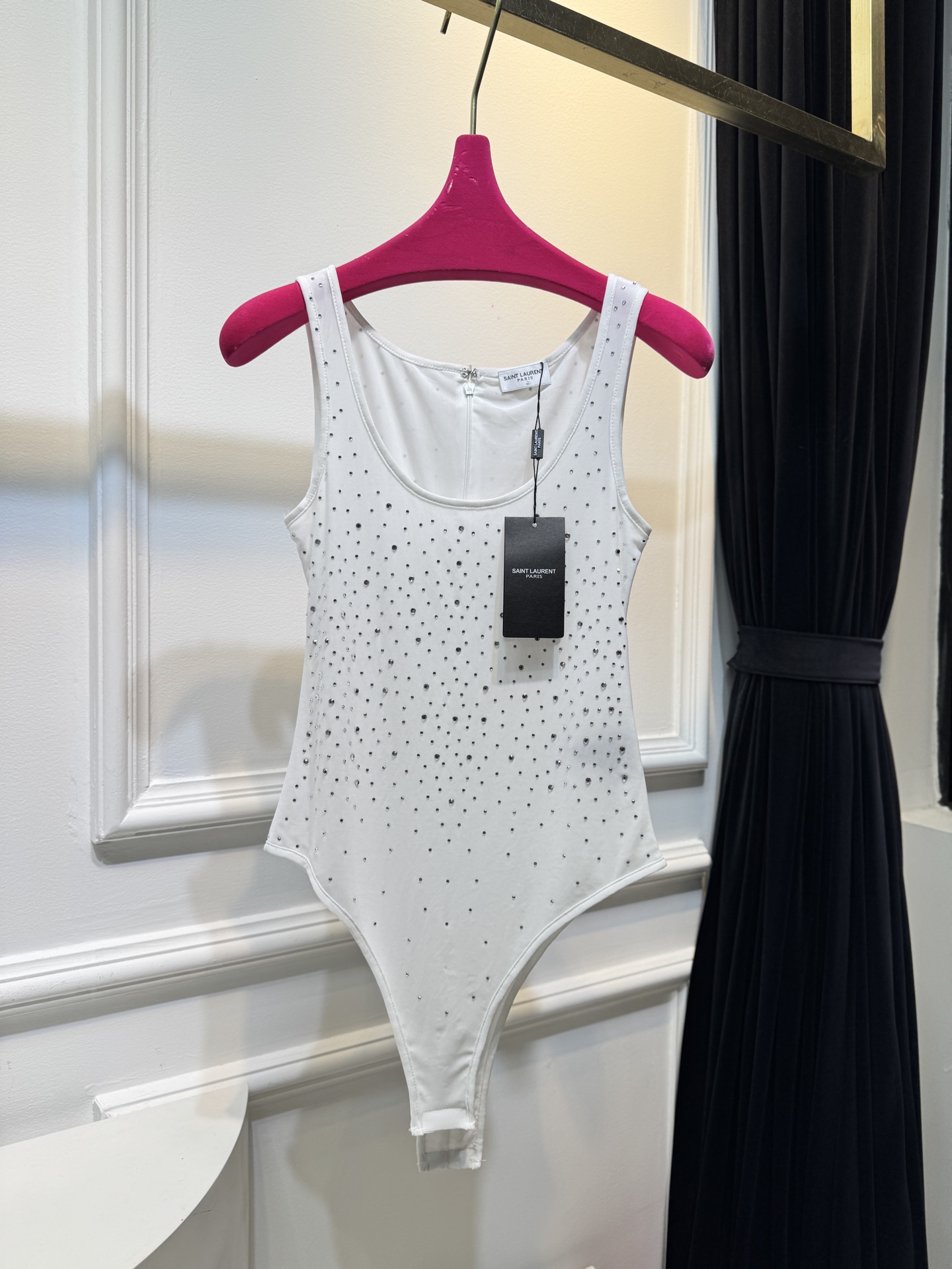 slp水钻连体衣通体装饰水钻，采用无袖、低圆领剪裁，背部配备拉链与底部按扣设计，兼具装饰性与穿脱便利性融