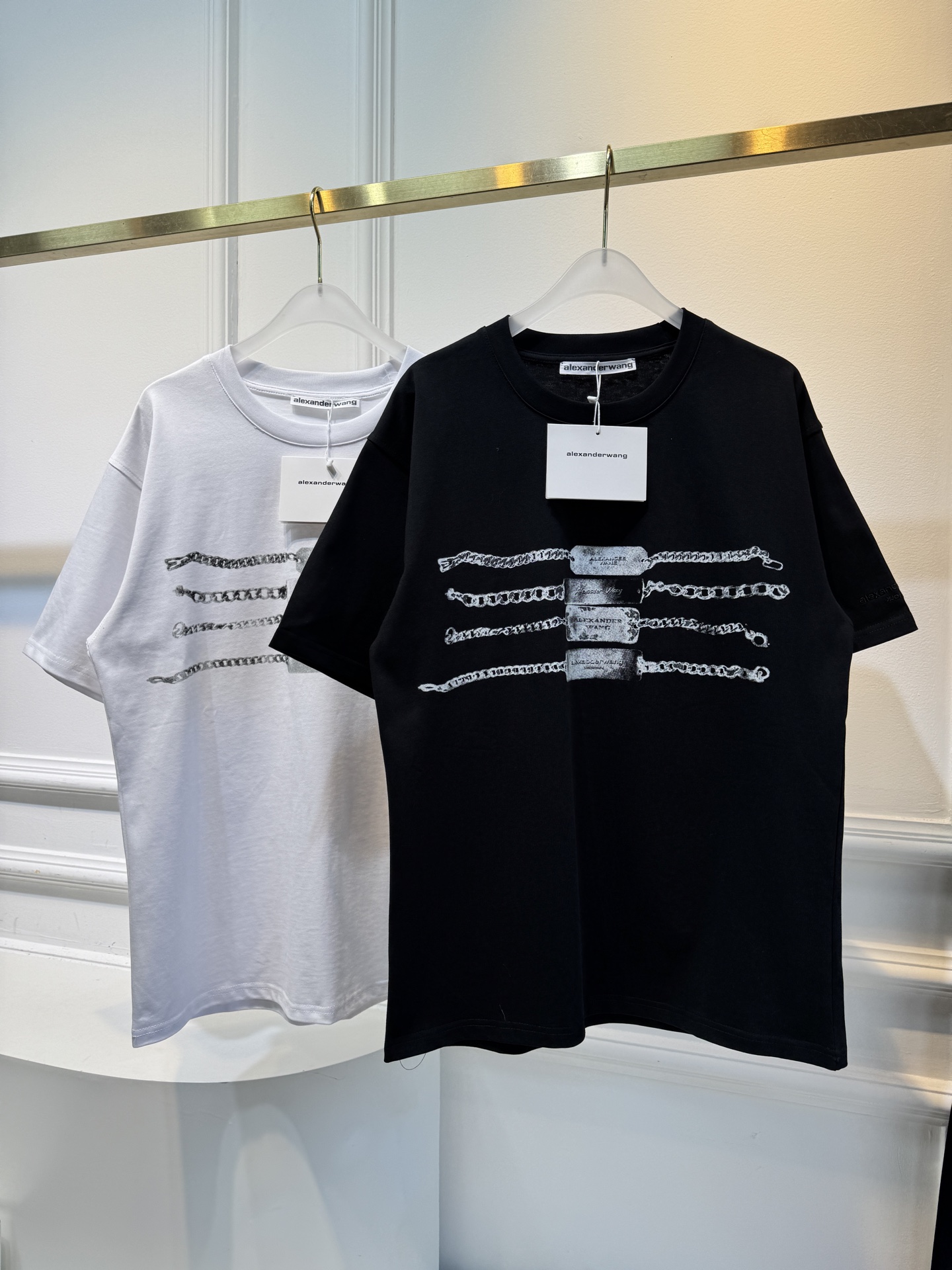 alexanderwang AW链条印花短袖T恤整体为宽松版型的基础款T恤，正面印有黑色链条+做旧金属牌