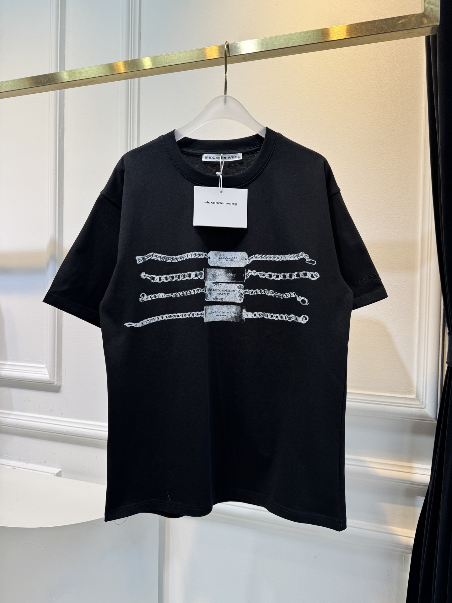 alexanderwang AW链条印花短袖T恤整体为宽松版型的基础款T恤，正面印有黑色链条+做旧金属牌
