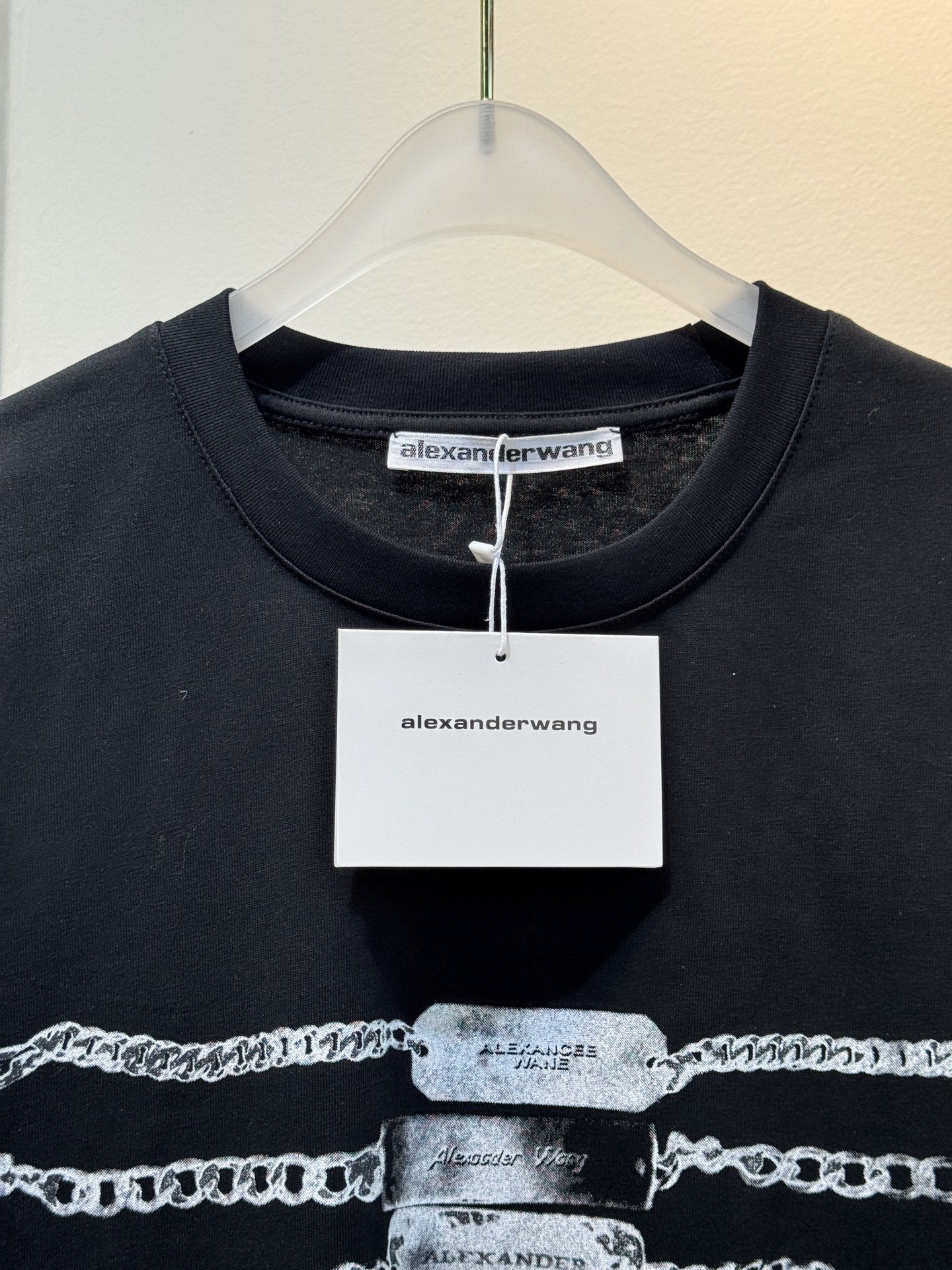 alexanderwang AW链条印花短袖T恤整体为宽松版型的基础款T恤，正面印有黑色链条+做旧金属牌