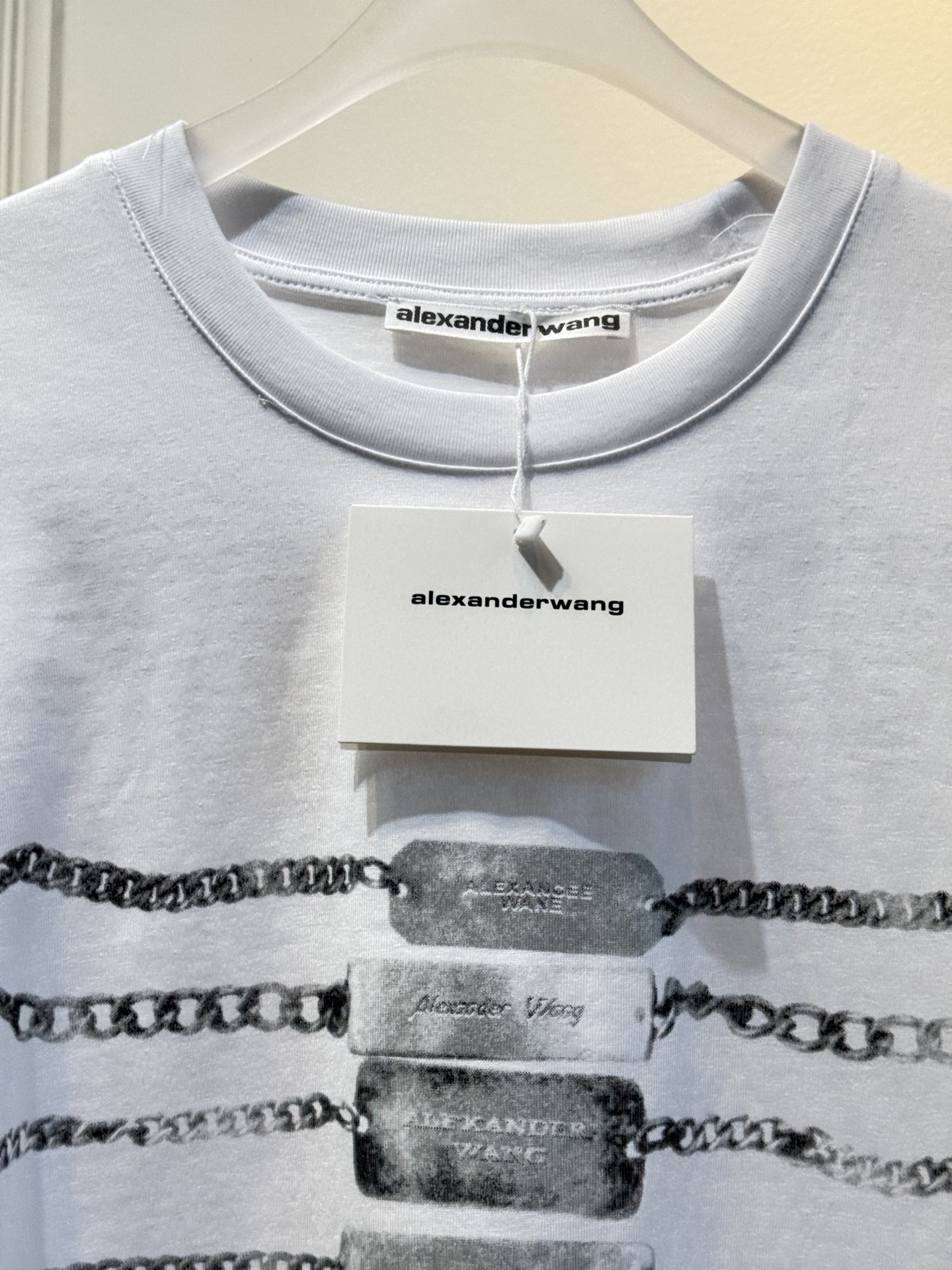 alexanderwang AW链条印花短袖T恤整体为宽松版型的基础款T恤，正面印有黑色链条+做旧金属牌