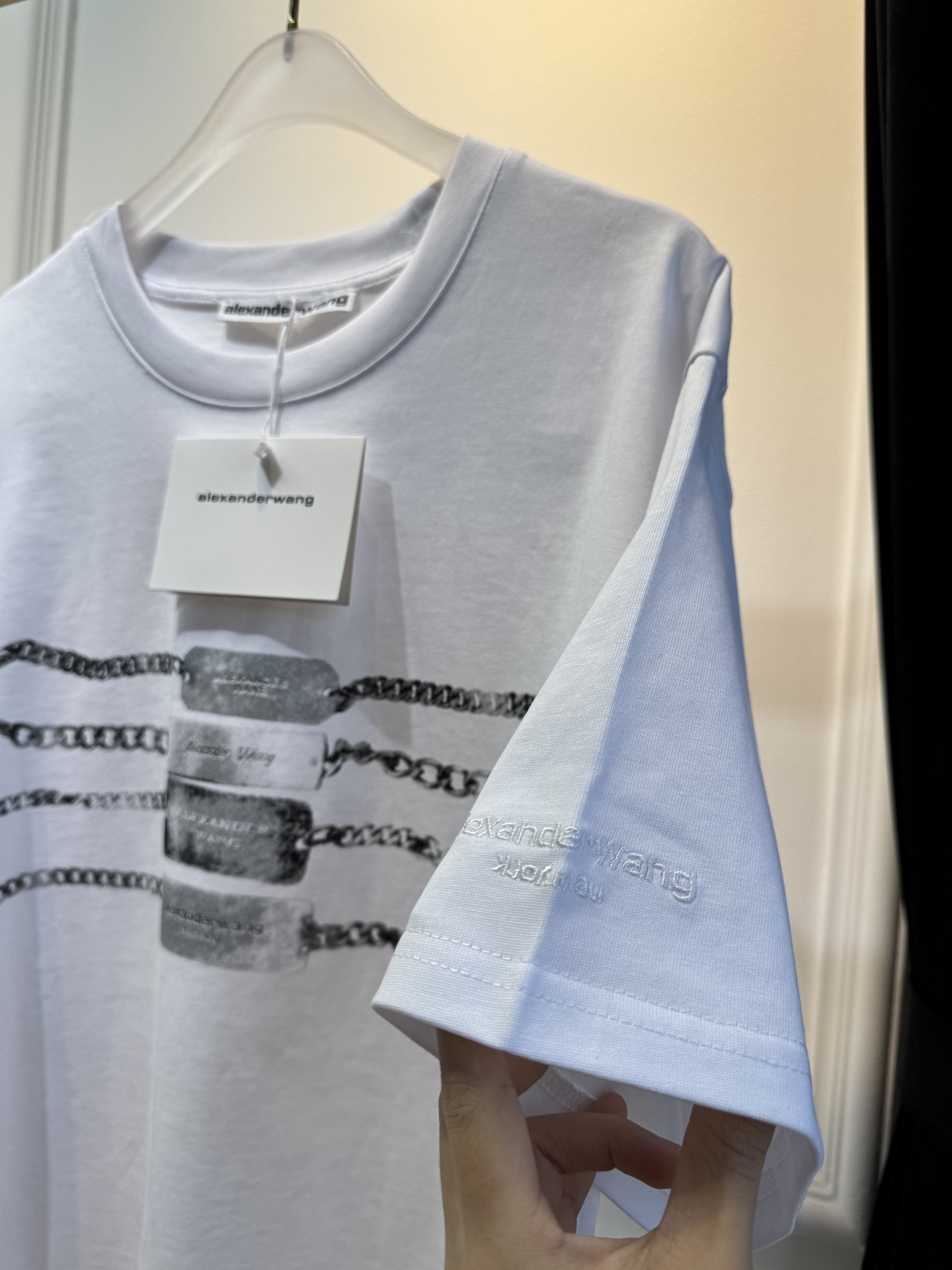 alexanderwang AW链条印花短袖T恤整体为宽松版型的基础款T恤，正面印有黑色链条+做旧金属牌