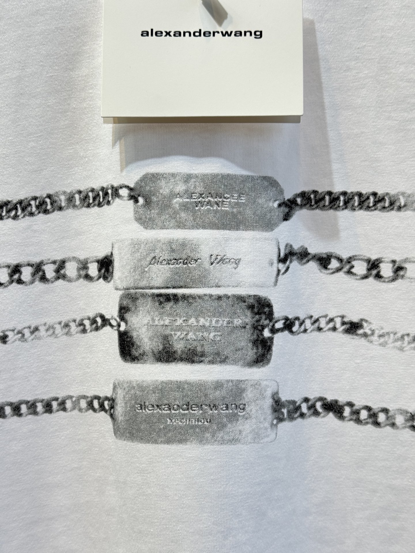 alexanderwang AW链条印花短袖T恤整体为宽松版型的基础款T恤，正面印有黑色链条+做旧金属牌