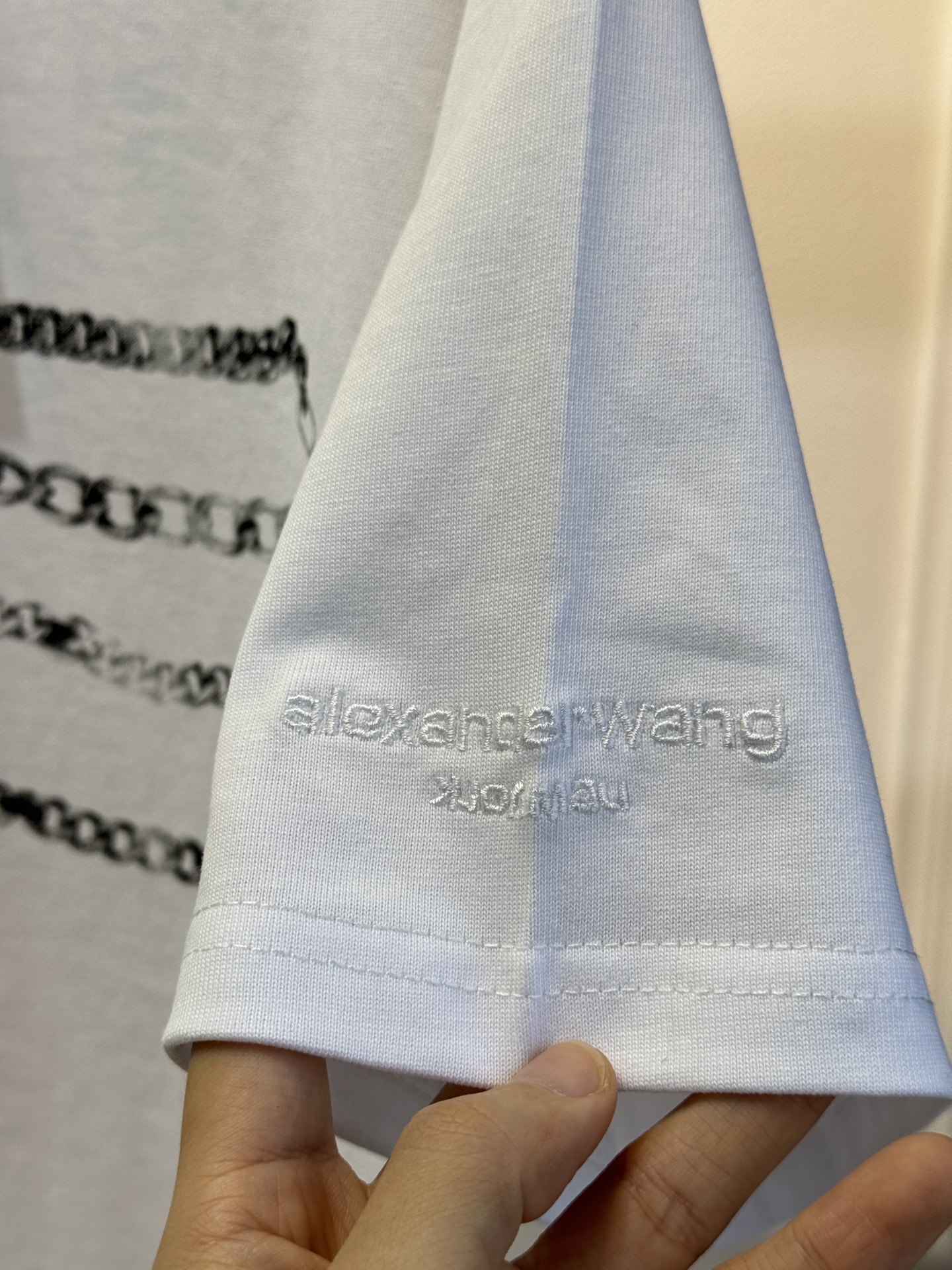 alexanderwang AW链条印花短袖T恤整体为宽松版型的基础款T恤，正面印有黑色链条+做旧金属牌