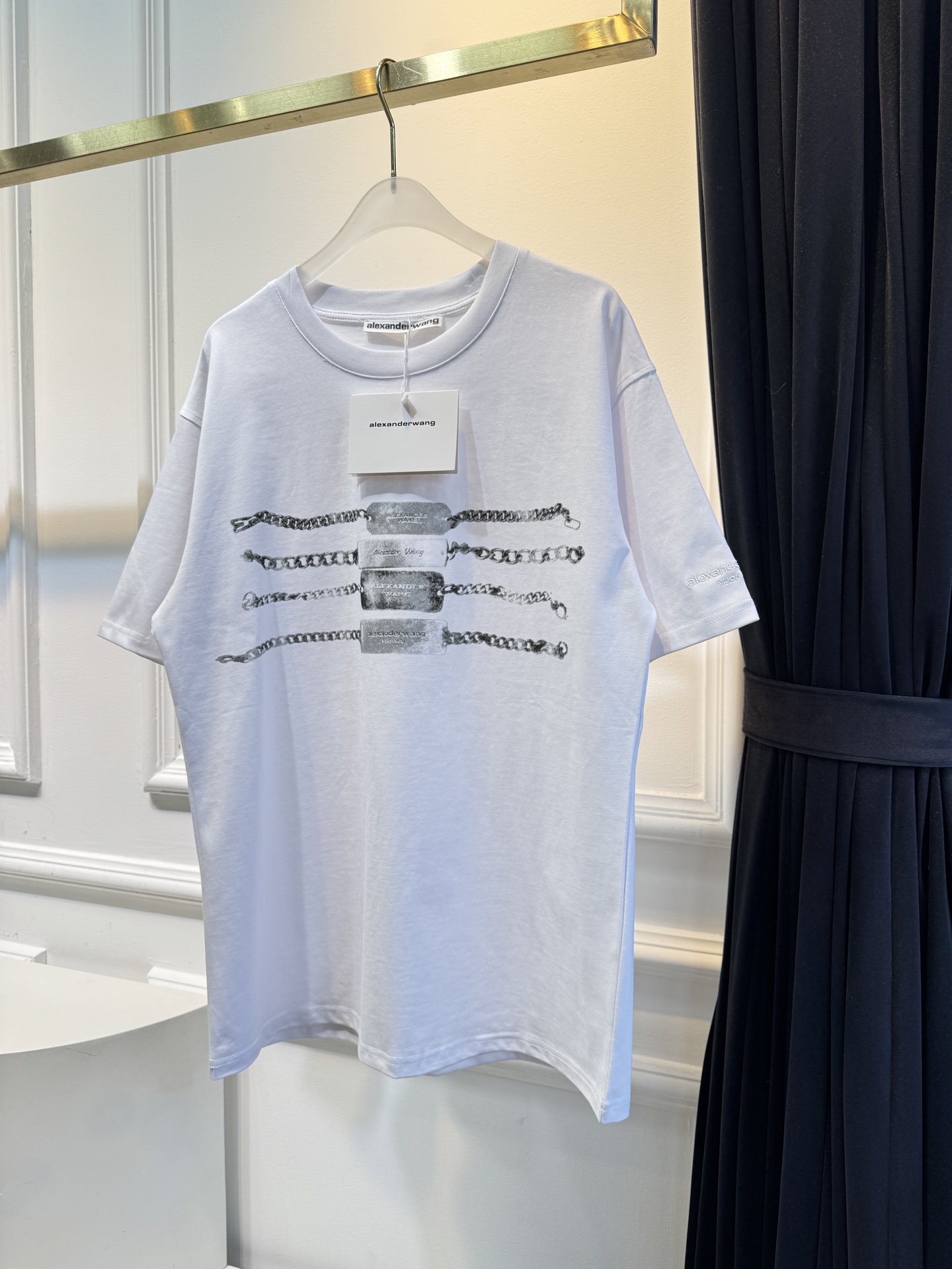 alexanderwang AW链条印花短袖T恤整体为宽松版型的基础款T恤，正面印有黑色链条+做旧金属牌