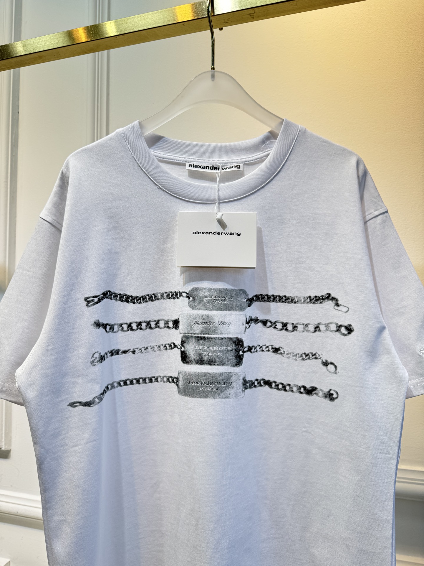 alexanderwang AW链条印花短袖T恤整体为宽松版型的基础款T恤，正面印有黑色链条+做旧金属牌