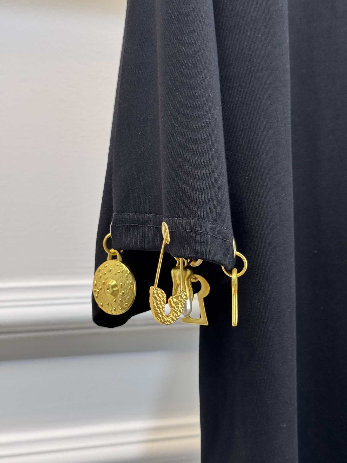 Schiaparelli（夏帕瑞丽）吊坠T恤采用oversize宽松圆领中袖版型，面料为柔软的棉质混纺，