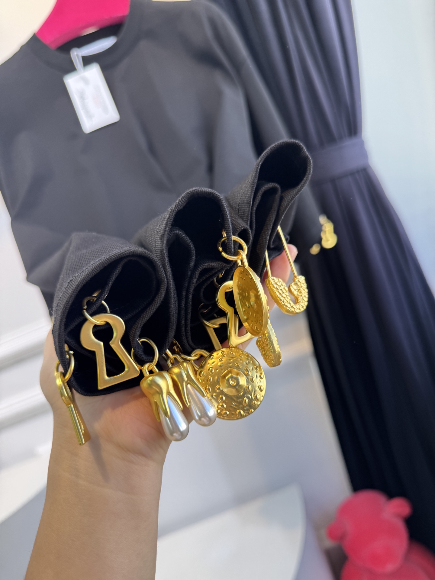 Schiaparelli（夏帕瑞丽）吊坠T恤采用oversize宽松圆领中袖版型，面料为柔软的棉质混纺，