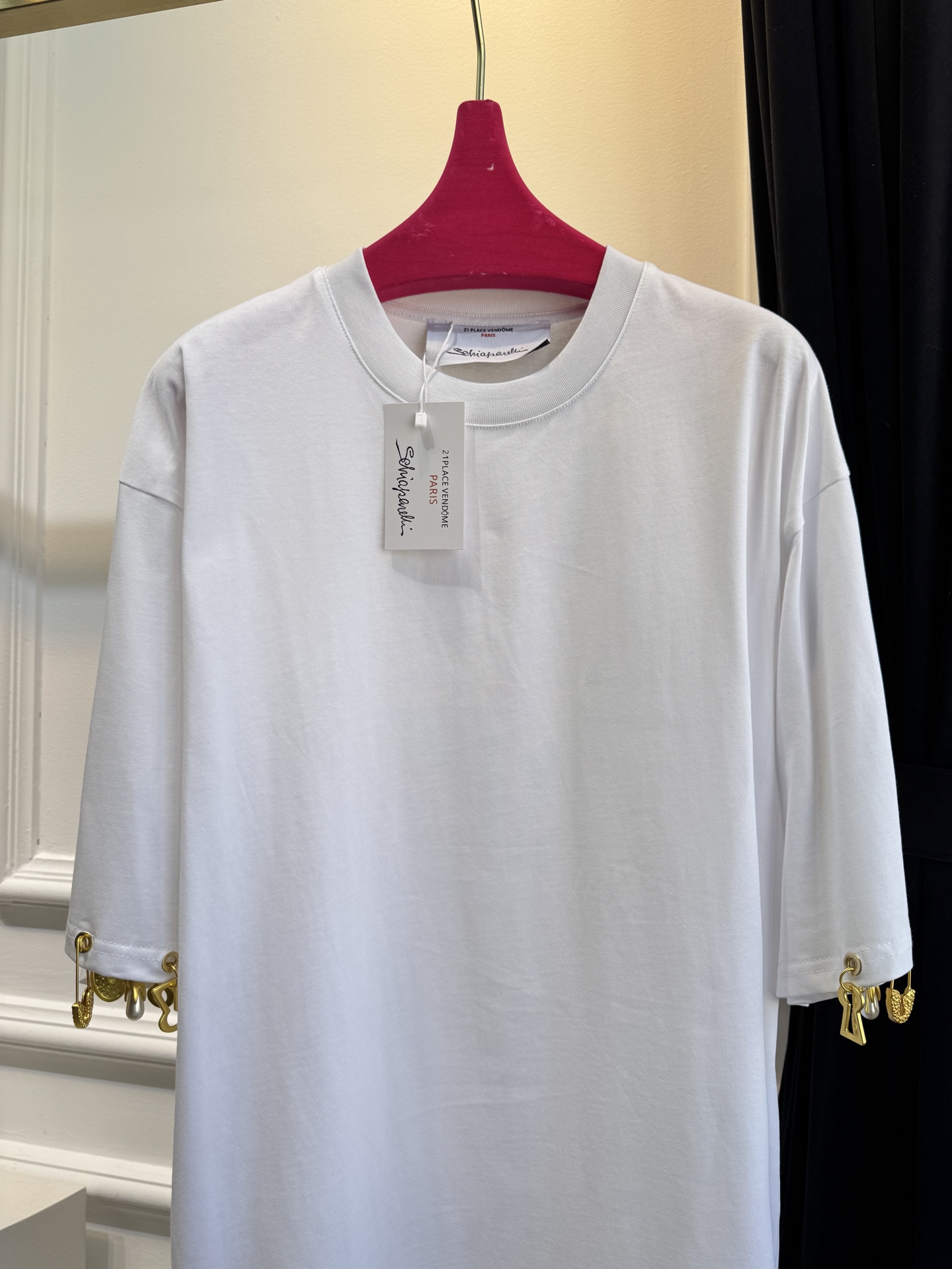 Schiaparelli（夏帕瑞丽）吊坠T恤采用oversize宽松圆领中袖版型，面料为柔软的棉质混纺，