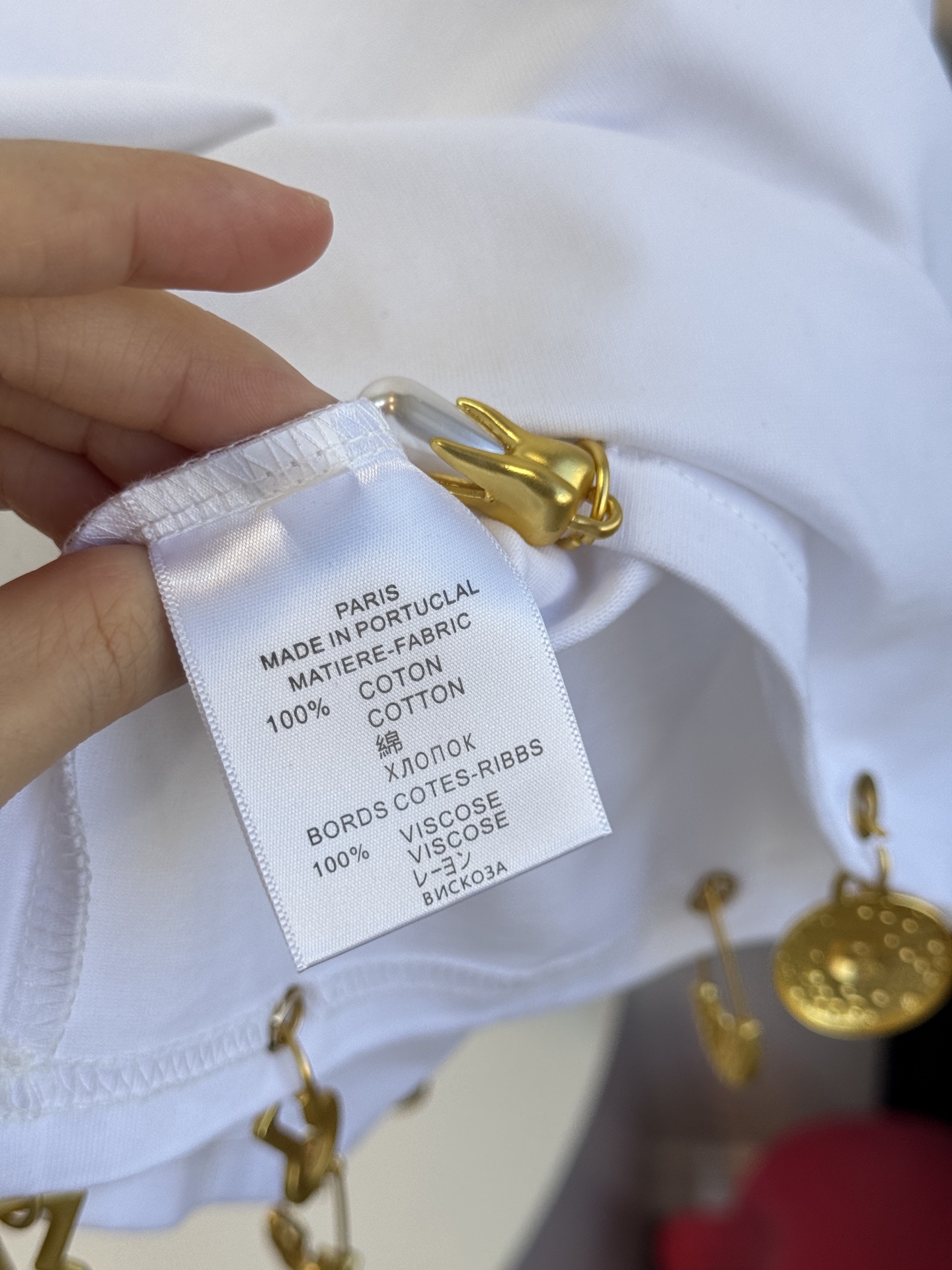 Schiaparelli（夏帕瑞丽）吊坠T恤采用oversize宽松圆领中袖版型，面料为柔软的棉质混纺，