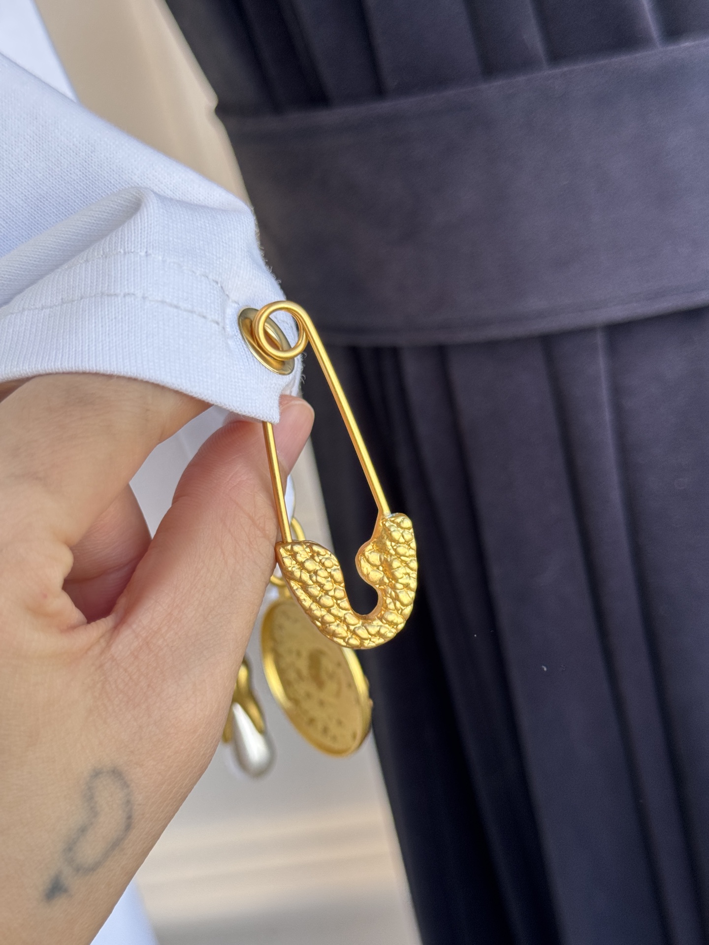 Schiaparelli（夏帕瑞丽）吊坠T恤采用oversize宽松圆领中袖版型，面料为柔软的棉质混纺，