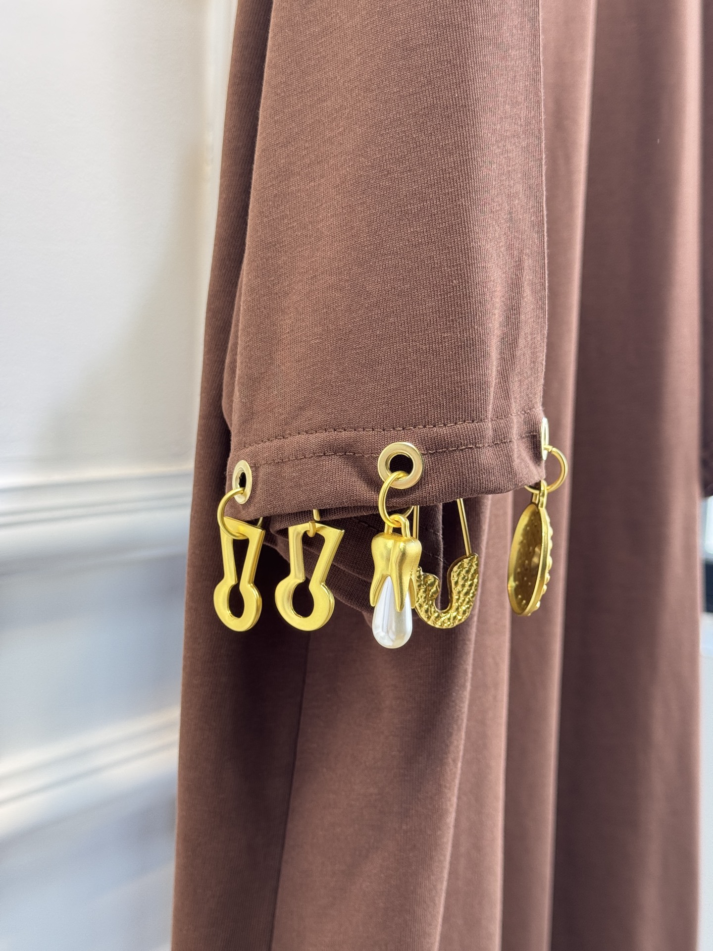 Schiaparelli（夏帕瑞丽）吊坠T恤采用oversize宽松圆领中袖版型，面料为柔软的棉质混纺，