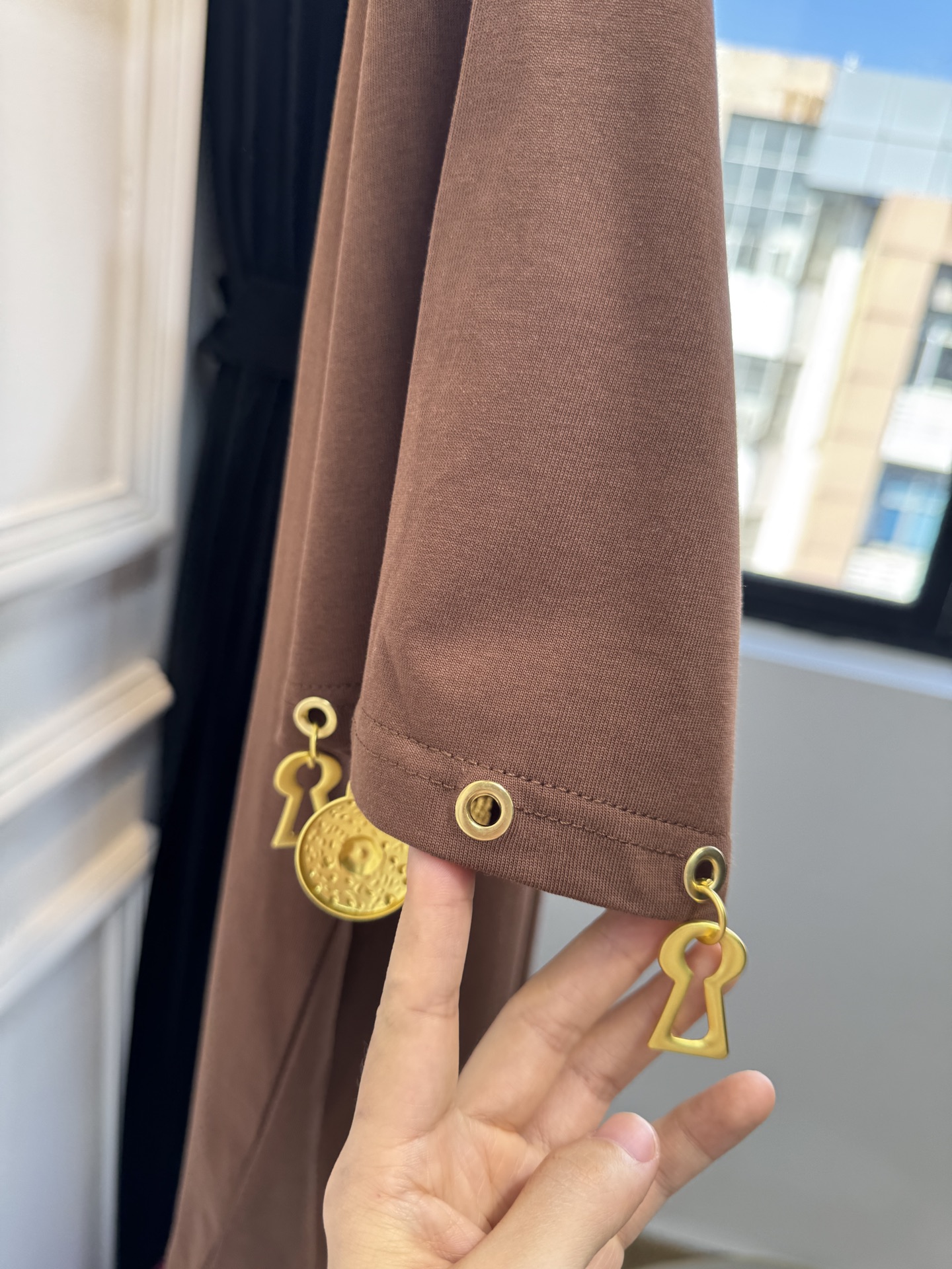 Schiaparelli（夏帕瑞丽）吊坠T恤采用oversize宽松圆领中袖版型，面料为柔软的棉质混纺，