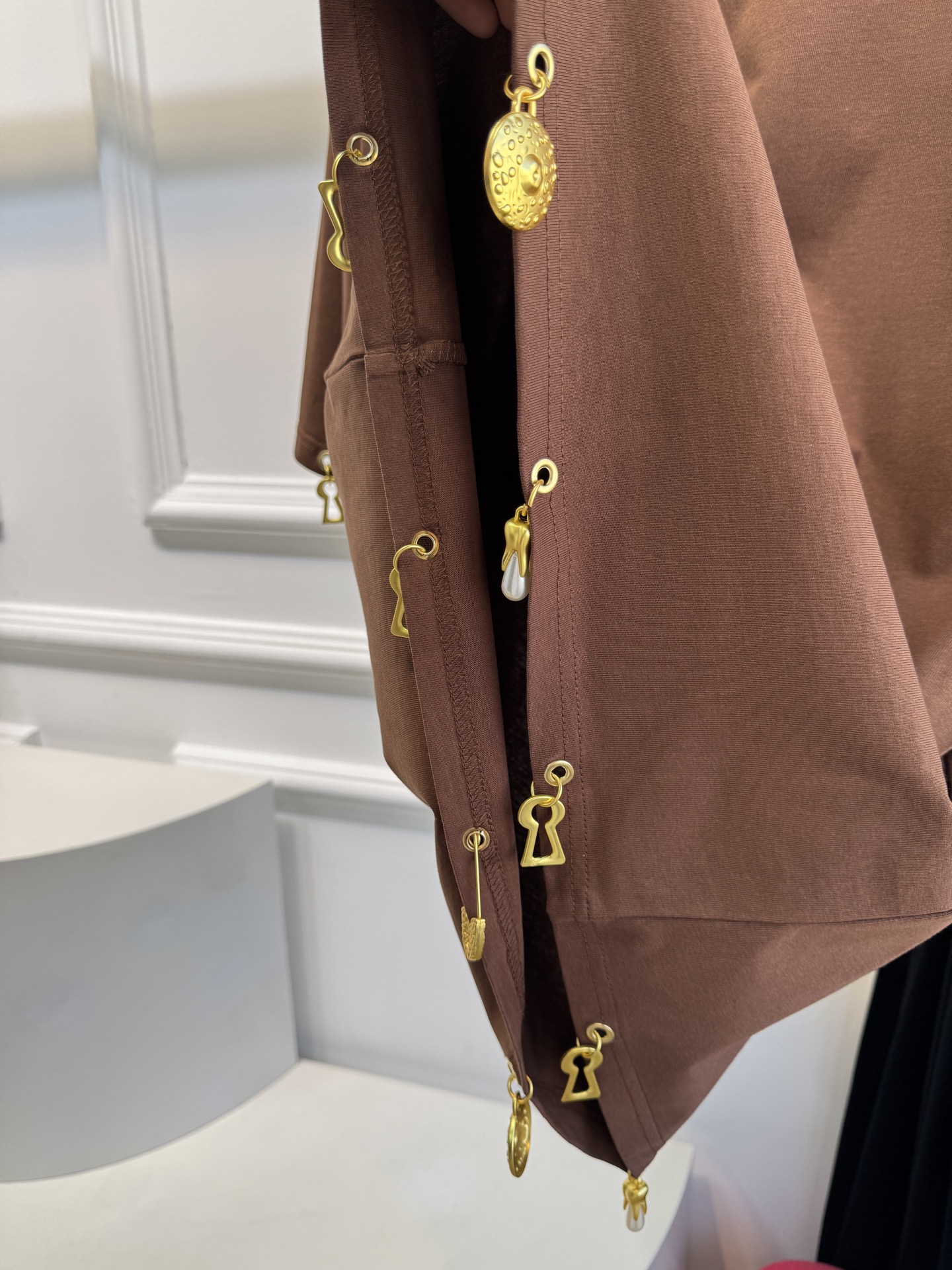 Schiaparelli（夏帕瑞丽）吊坠T恤采用oversize宽松圆领中袖版型，面料为柔软的棉质混纺，