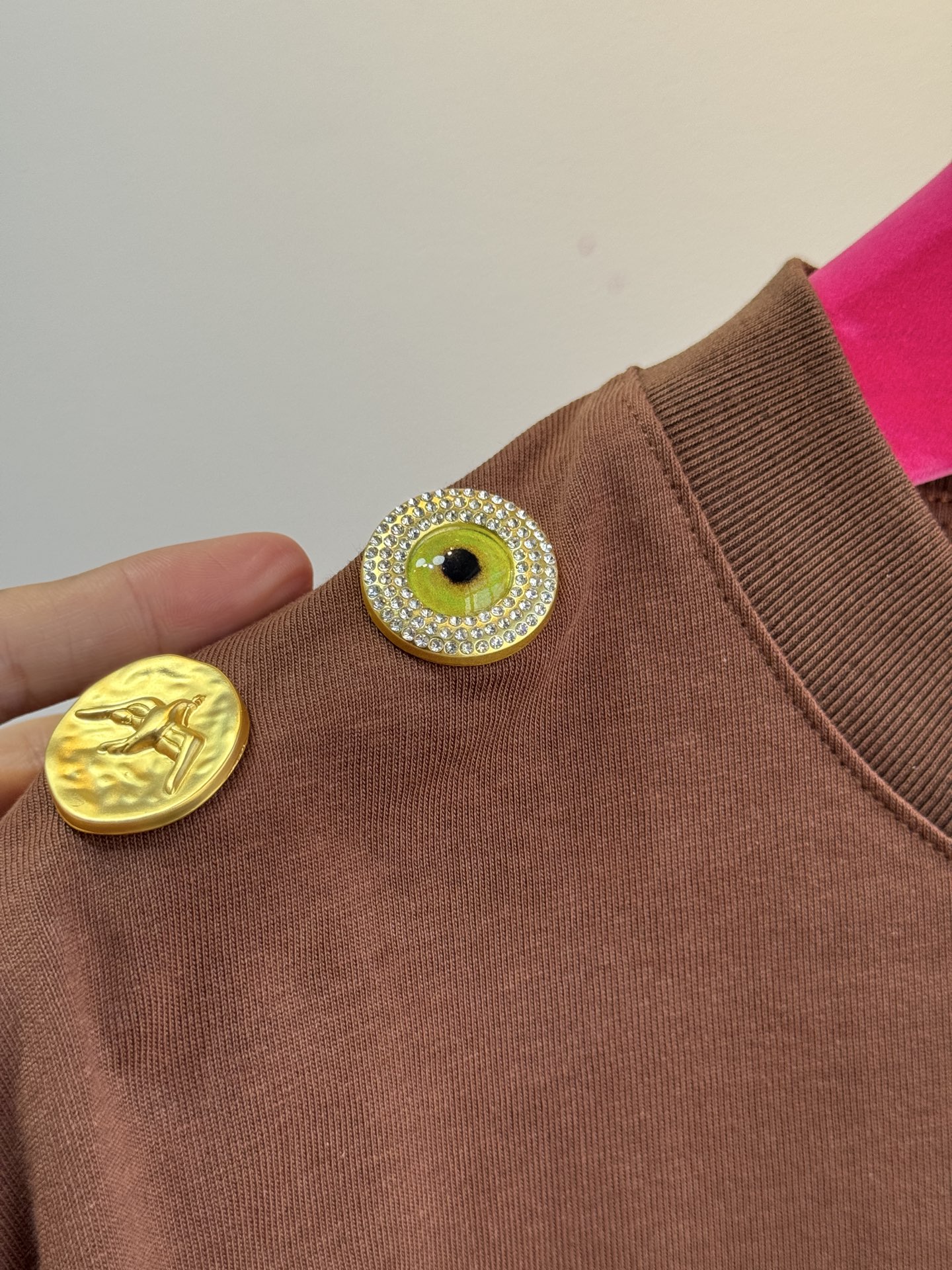 Schiaparelli（夏帕瑞丽) 肩部金属扣T恤采用oversize圆领短袖版型，面料为柔软的棉质混