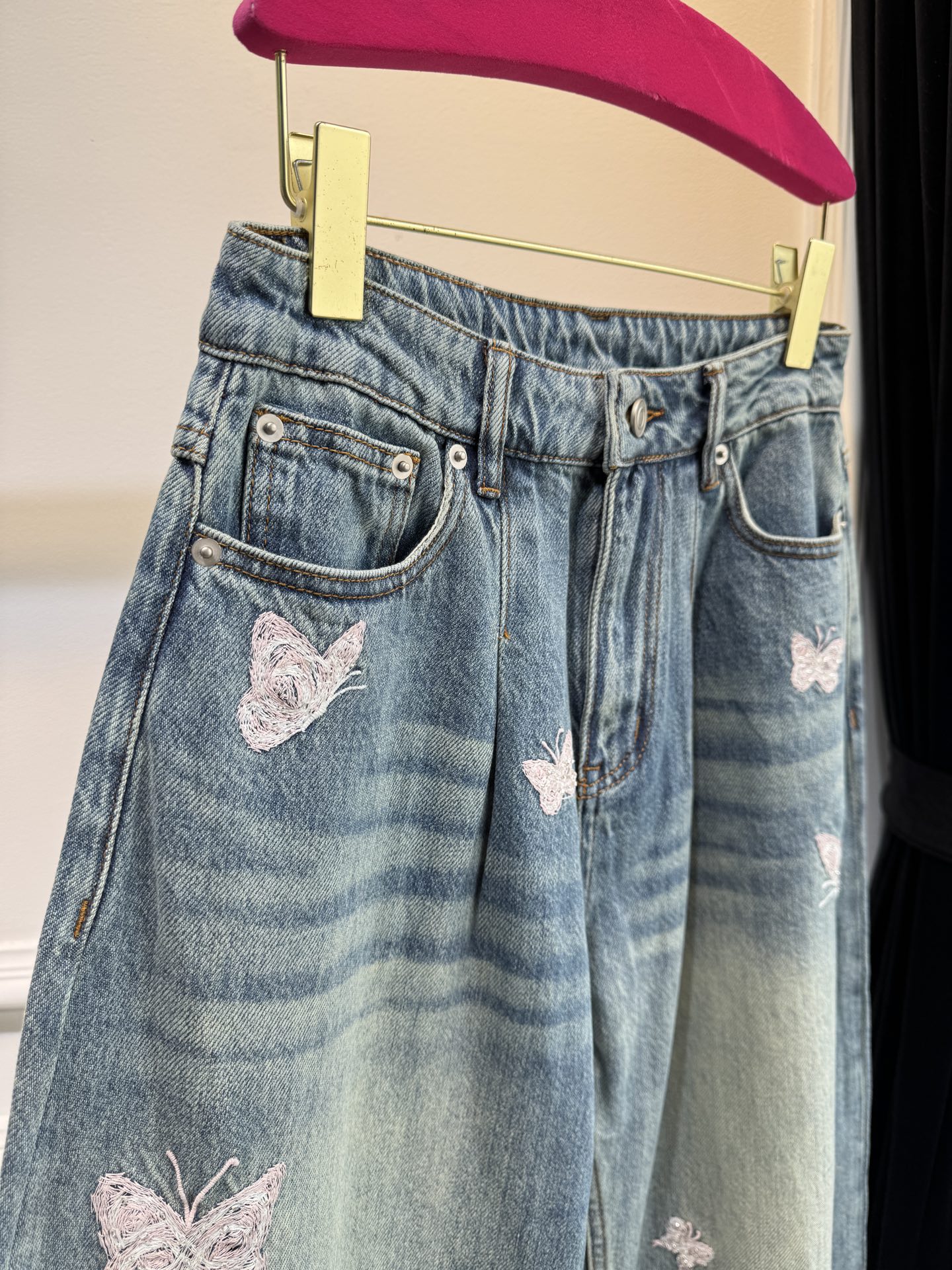 Ann Andel**蝴蝶刺绣弯刀牛仔裤融合轻奢设计与休闲丹宁风格的单品，以复古水洗丹宁为基底，搭配精致