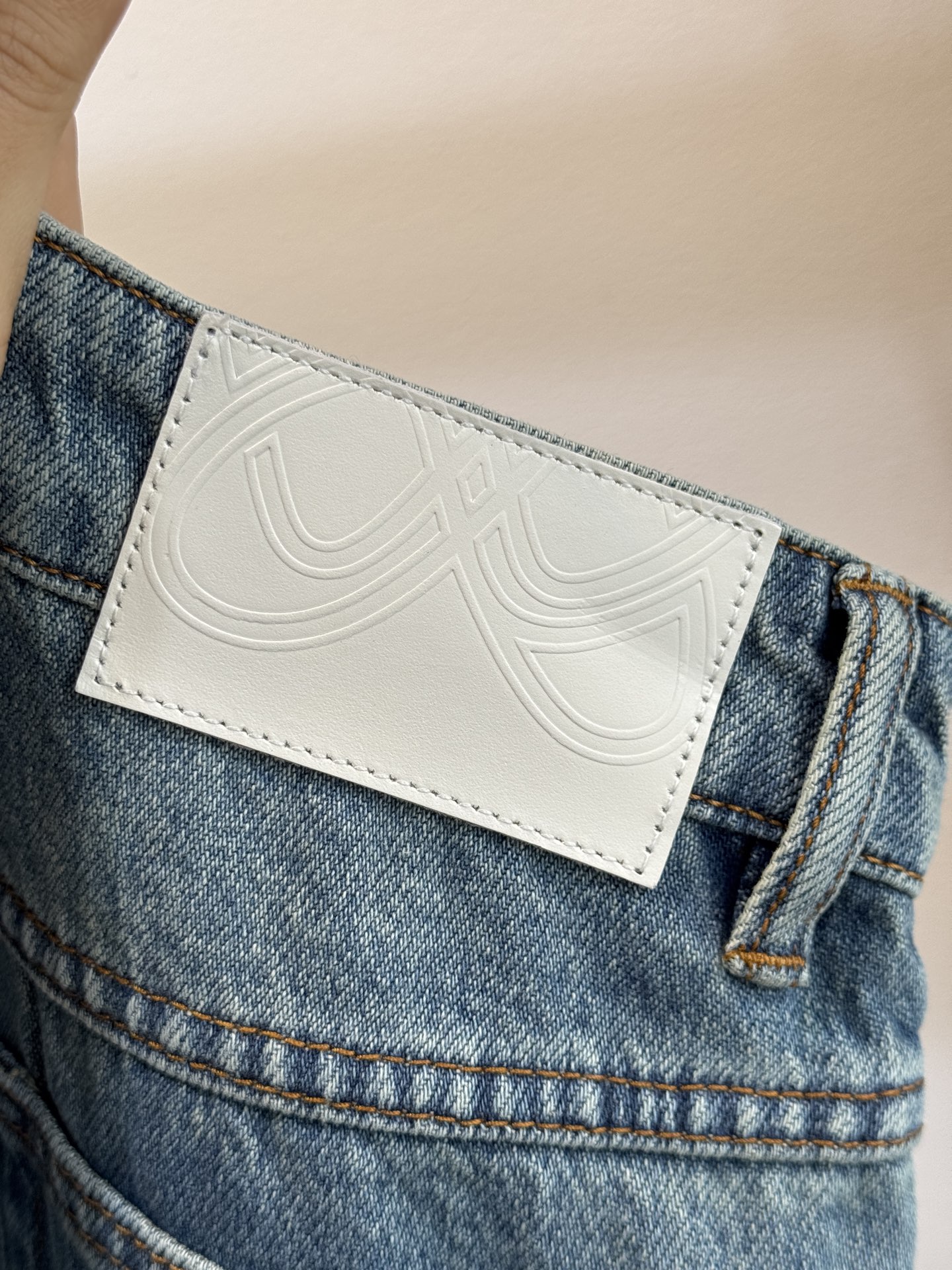 Ann Andel**蝴蝶刺绣弯刀牛仔裤融合轻奢设计与休闲丹宁风格的单品，以复古水洗丹宁为基底，搭配精致