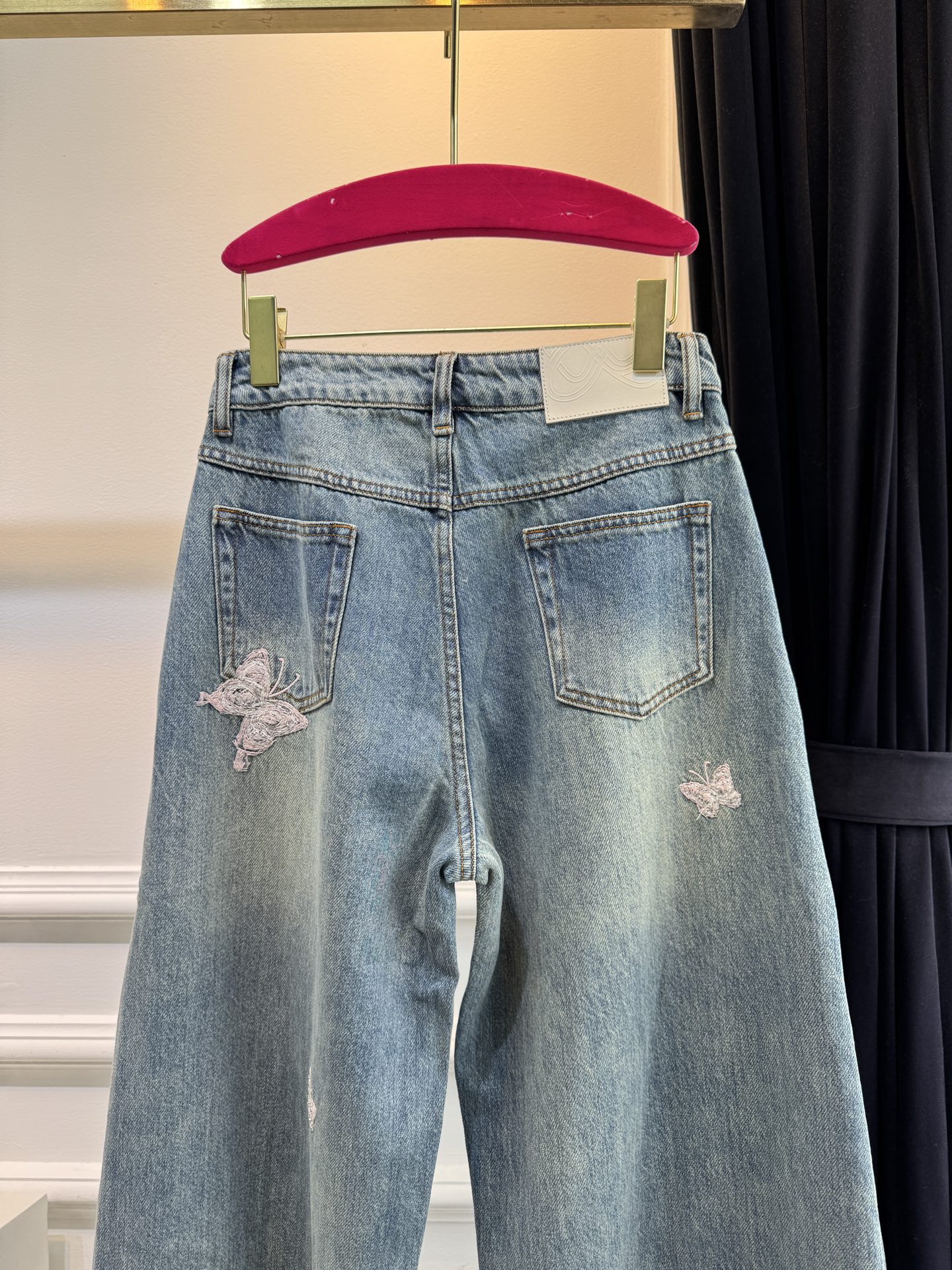 Ann Andel**蝴蝶刺绣弯刀牛仔裤融合轻奢设计与休闲丹宁风格的单品，以复古水洗丹宁为基底，搭配精致