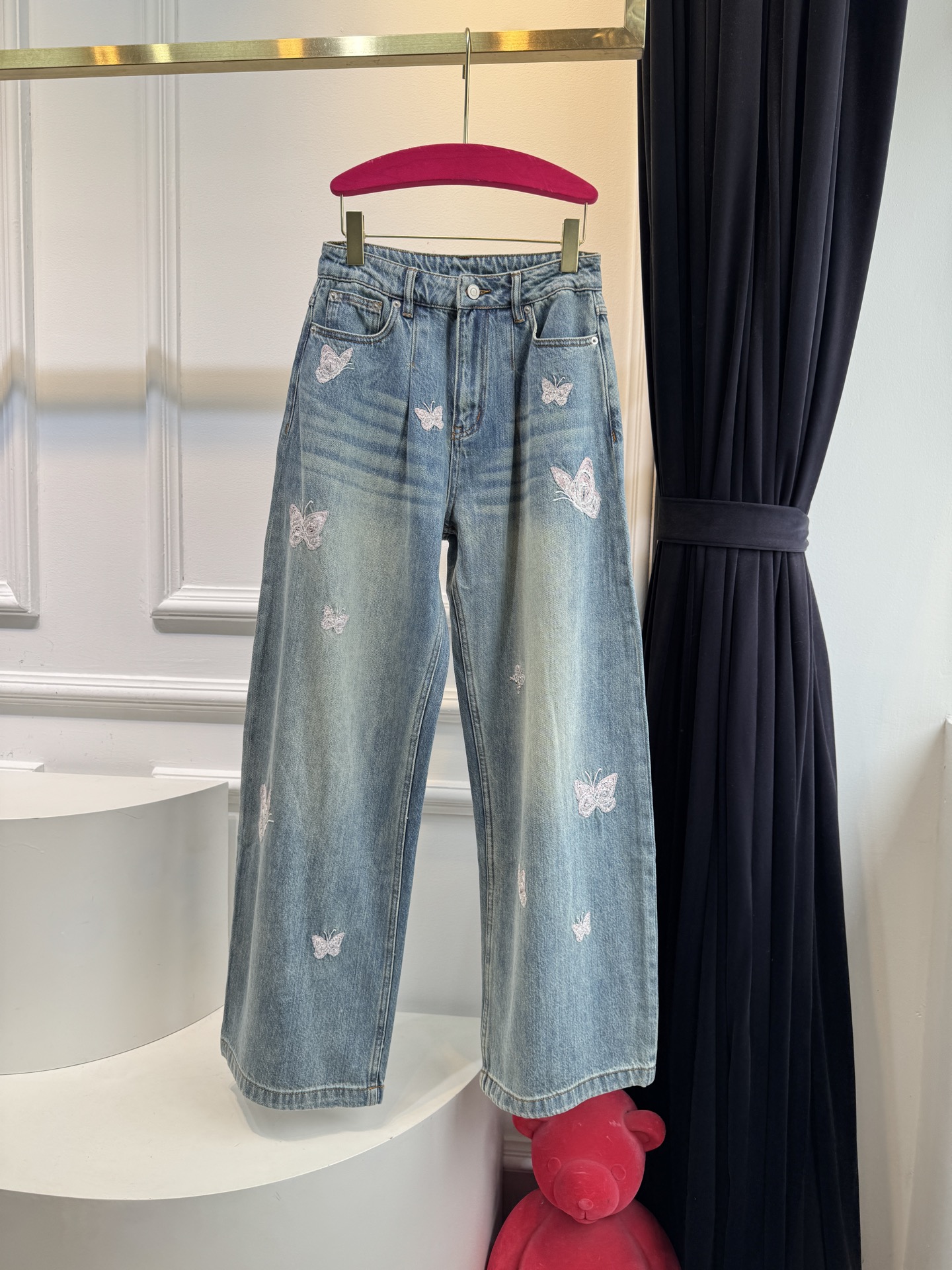 Ann Andel**蝴蝶刺绣弯刀牛仔裤融合轻奢设计与休闲丹宁风格的单品，以复古水洗丹宁为基底，搭配精致